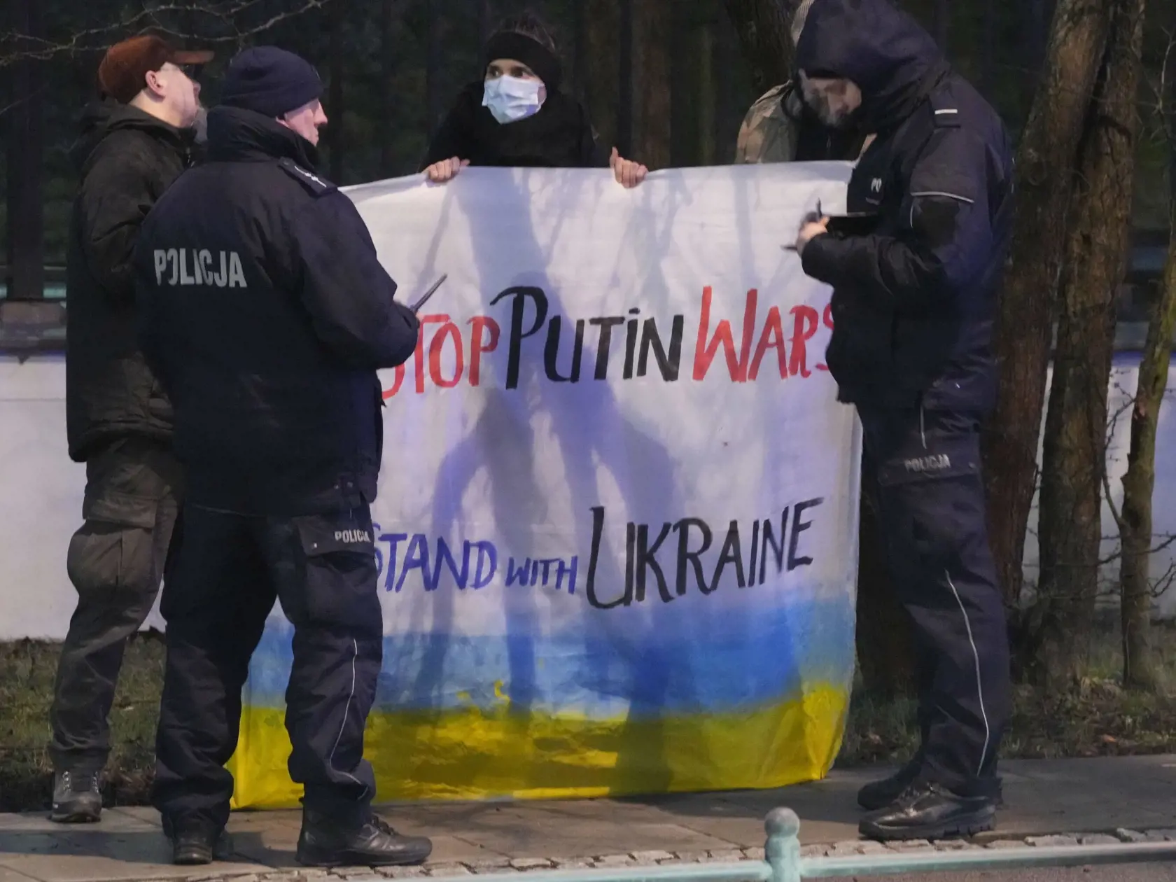 JB 32 Varšava - Policajti hovoria ku skupine ľudí, ktorí držia transparenty počas protestného zhromaždenia na podporu Ukrajiny pred ruským veľvyslanectvom vo Varšave 23. februára 2022. Ruské pozemné sily začali vo štvrtok vstupovať na územie Ukrajiny, informovala agentúra AFP s odvolaním sa na ukrajinskú pohraničnú stráž. Podľa nej ruské pozemné sily prešli na Ukrajinu z viacerých smerov.