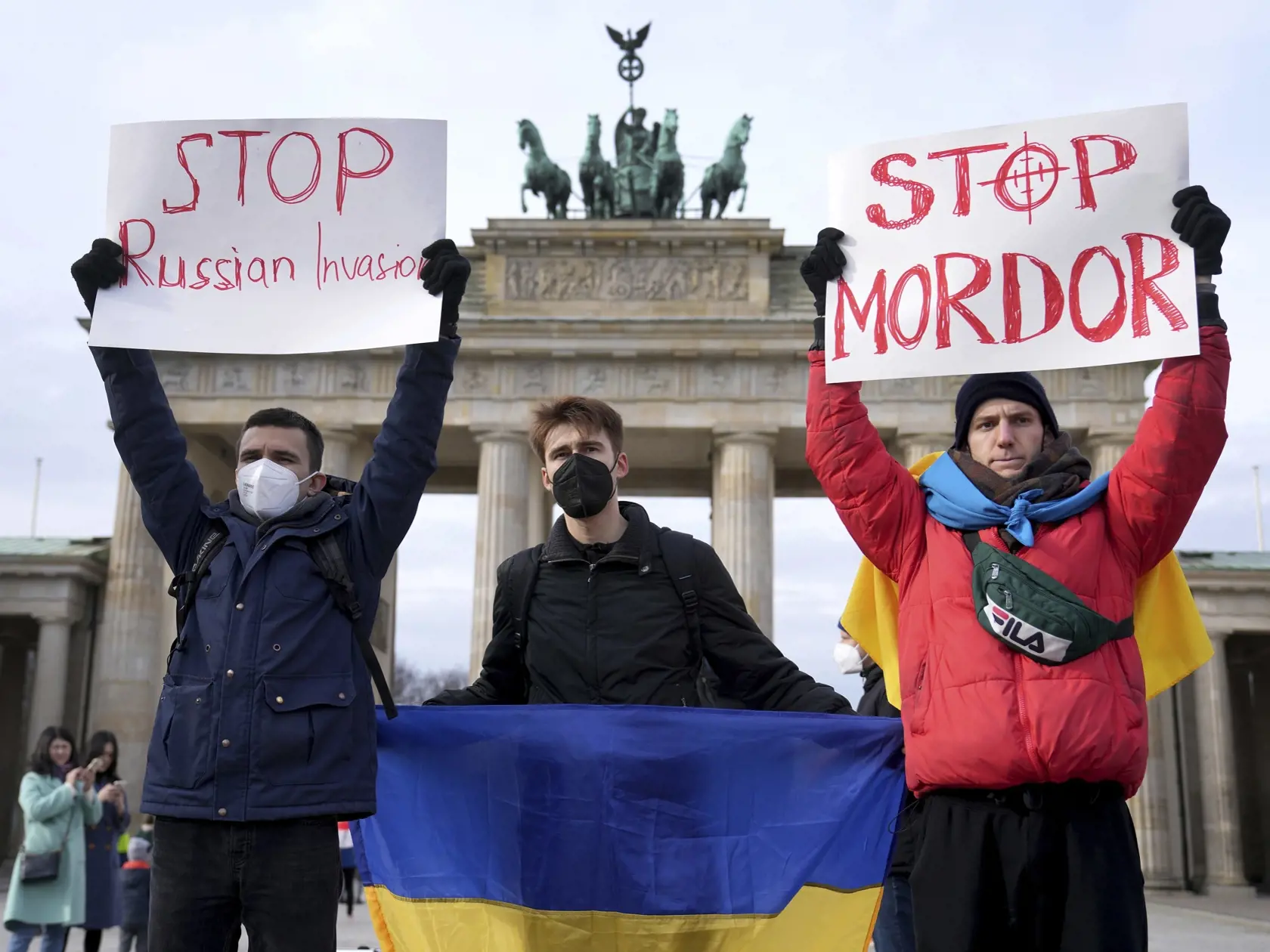JB 24 Berlín - Ľudia držia transparenty a ukrajinské zástavy počas protestného zhromaždenia proti ruským útokom na Ukrajine pred Brandenburskou bránou v Berlíne 24. februára 2022. Ruské pozemné sily začali vo štvrtok vstupovať na územie Ukrajiny, informovala agentúra AFP s odvolaním sa na ukrajinskú pohraničnú stráž. Podľa nej ruské pozemné sily prešli na Ukrajinu z viacerých smerov.