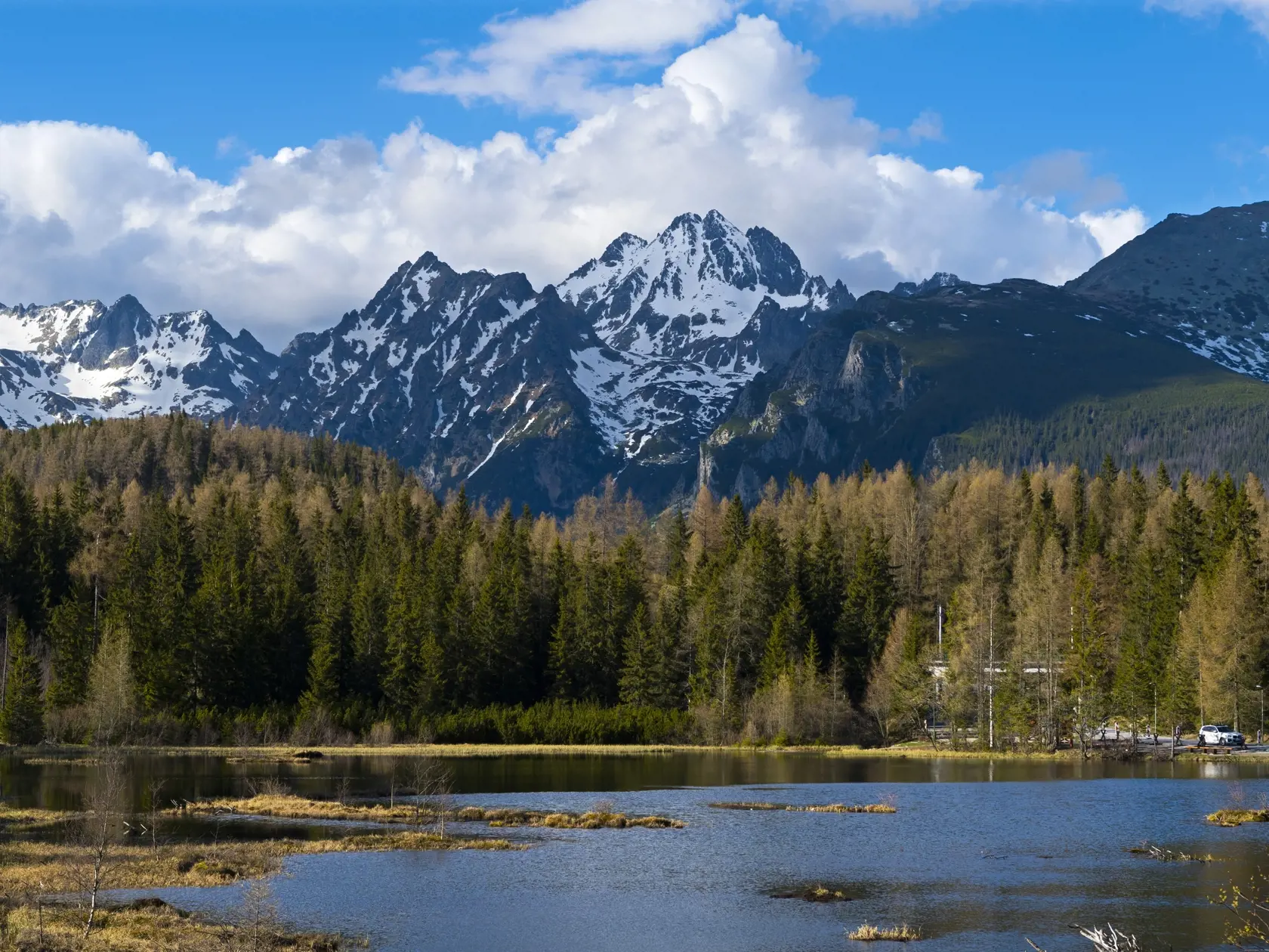 Nové Štrbské pleso pod známejším Štrbským plesom tiež poskytuje pekné pohľady na okolité tatranské štíty.Na snímke uprostred Kôpky a masív Vysokej. Štrbské Pleso, 14. mája 2020. FOTO TASR – Milan Kapusta  
