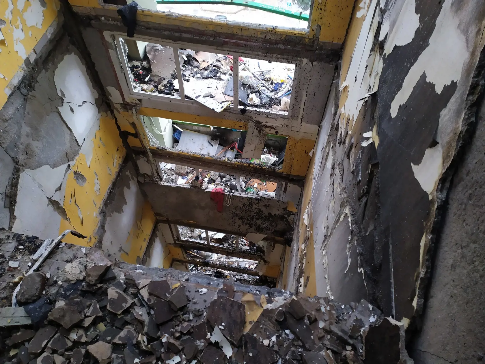 Zábery z vnútorných priestorov zhorenej bytovky na Mukačevskej č. 7 v Prešove - zrútené schodisko.