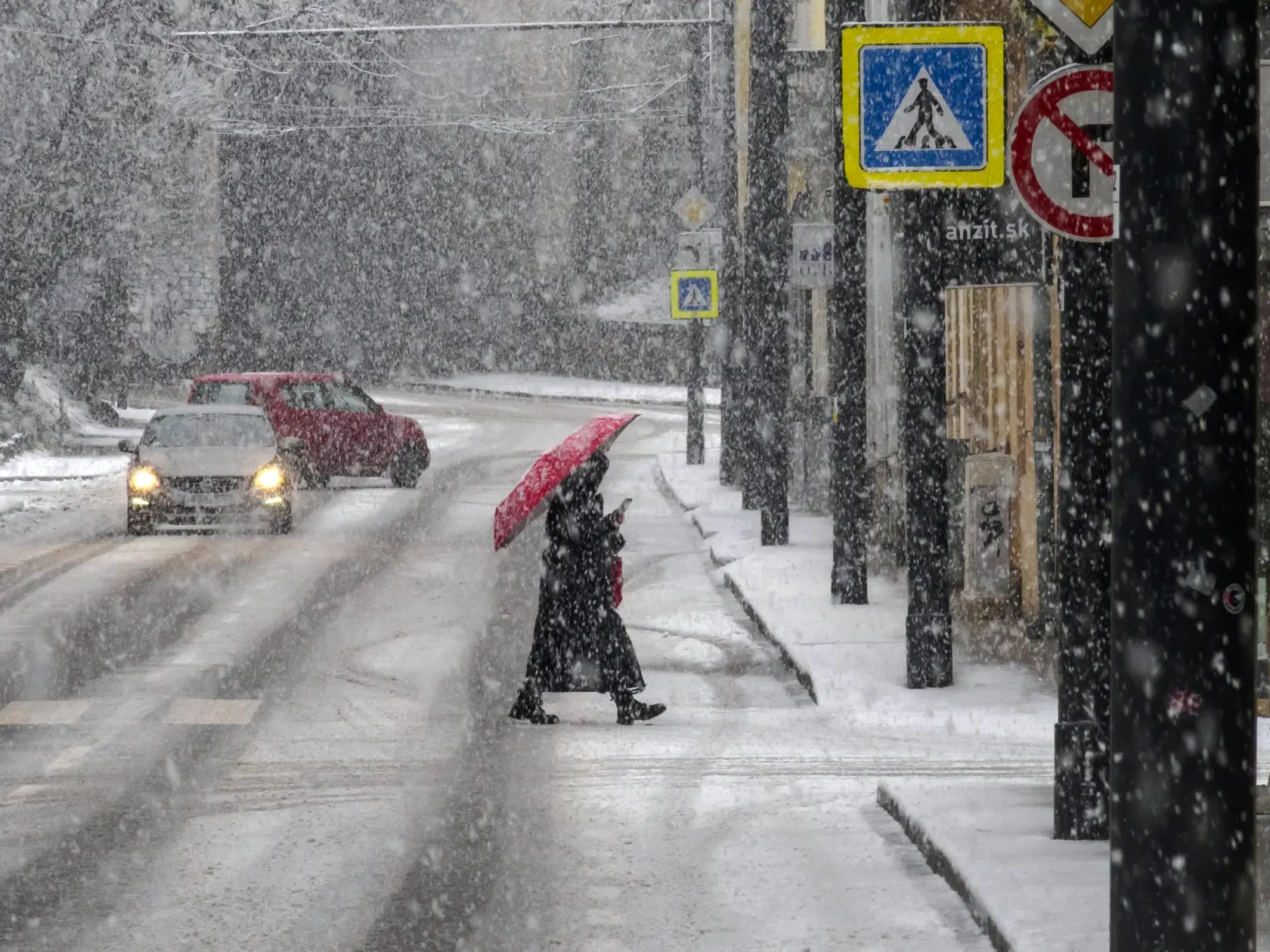 Na snímke žena s dáždnikom kráča počas hustého sneženia po Karpatskej ulici v Bratislave 23. decembra 2023. FOTO TASR - Dano Veselský