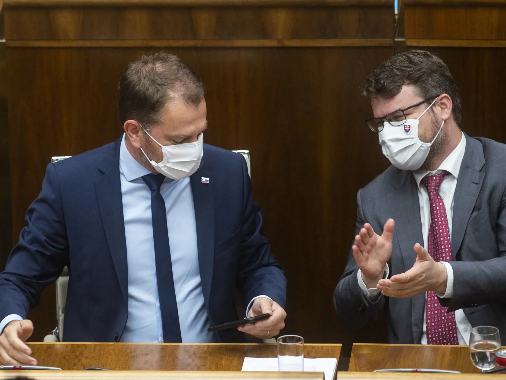 Predsedu vlády SR Igora Matoviča sa opozícii nepodarilo odvolať počas mimoriadnej schôdze, na ktorej po prvý raz od nástupu do funkcie čelil odvolávaniu. Návrh vyslovenie nedôvery predložili opoziční poslanci Juraj Blanár (Smer-SD) a Richard Raši (nezaradený) po medializácii podozrení, že Matovičova diplomová práca je plagiát. Na snímke predseda vlády SR Igor Matovič (vľavo) a podpredseda vlády pre legislatívu Štefan Hollý (Sme rodina) 24. júla 2020 v Bratislave. FOTO TASR - Jakub Kotian
