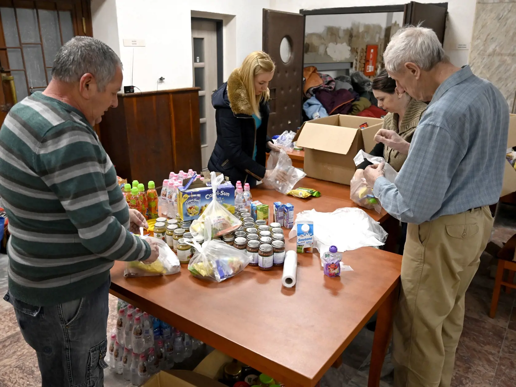 Na snímke balenie potravinových balíčkov v sklade humanitárnej pomoci pre utečencov z Ukrajiny v priestoroch Mestského kultúrneho strediska (MKS) v meste Veľké Kapušany 2. marca 2022. FOTO TASR - Roman Hanc