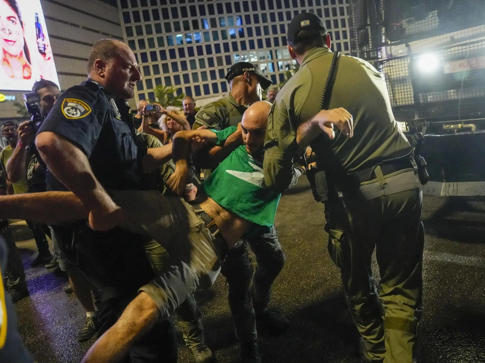 Policajti zadržali demonštranta počas protivládneho protestu v Tel Avive v sobotu 8. júna 2024. Demonštranti vyzývali na prijatie dohody o prepustení zvyšných zajatcov odvlečených militantmi do Pásma Gazy po vlaňajšom útoku na Izrael. Na demonštrácii v Tel Avive sa strhla potýčka s políciou, keď sa protestujúci pokúsili zablokovať diaľnicu. Podľa izraelských médií polícia na rozohnanie davu použila vodné delá.