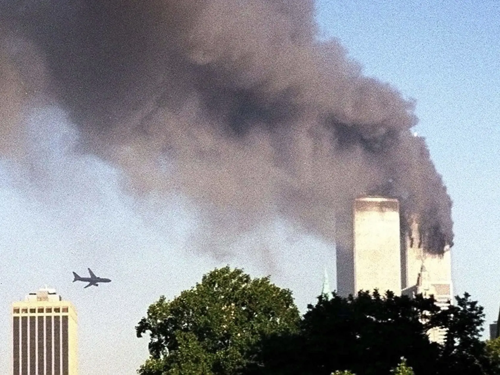 Na archívnej snímke z 11. septembra 2001 v New Yorku lietadlo letí krátko pred narazením do druhej veže (vľavo) Svetového obchodného centra v New Yorku (WTC).