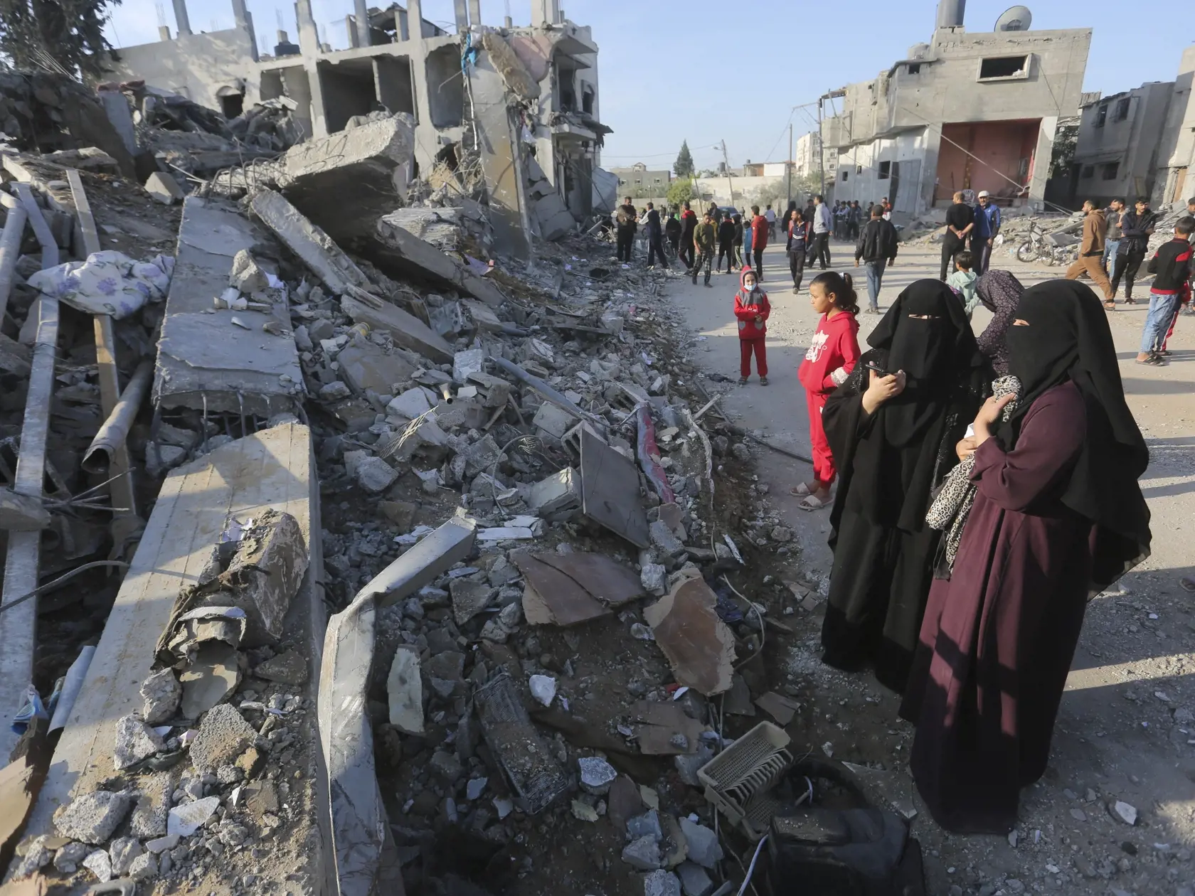 Palestínčania sa pozerajú na škody po  izraelskom leteckom útoku v meste Rafah na juhu Pásma Gazy v pondelok 4. decembra 2023.