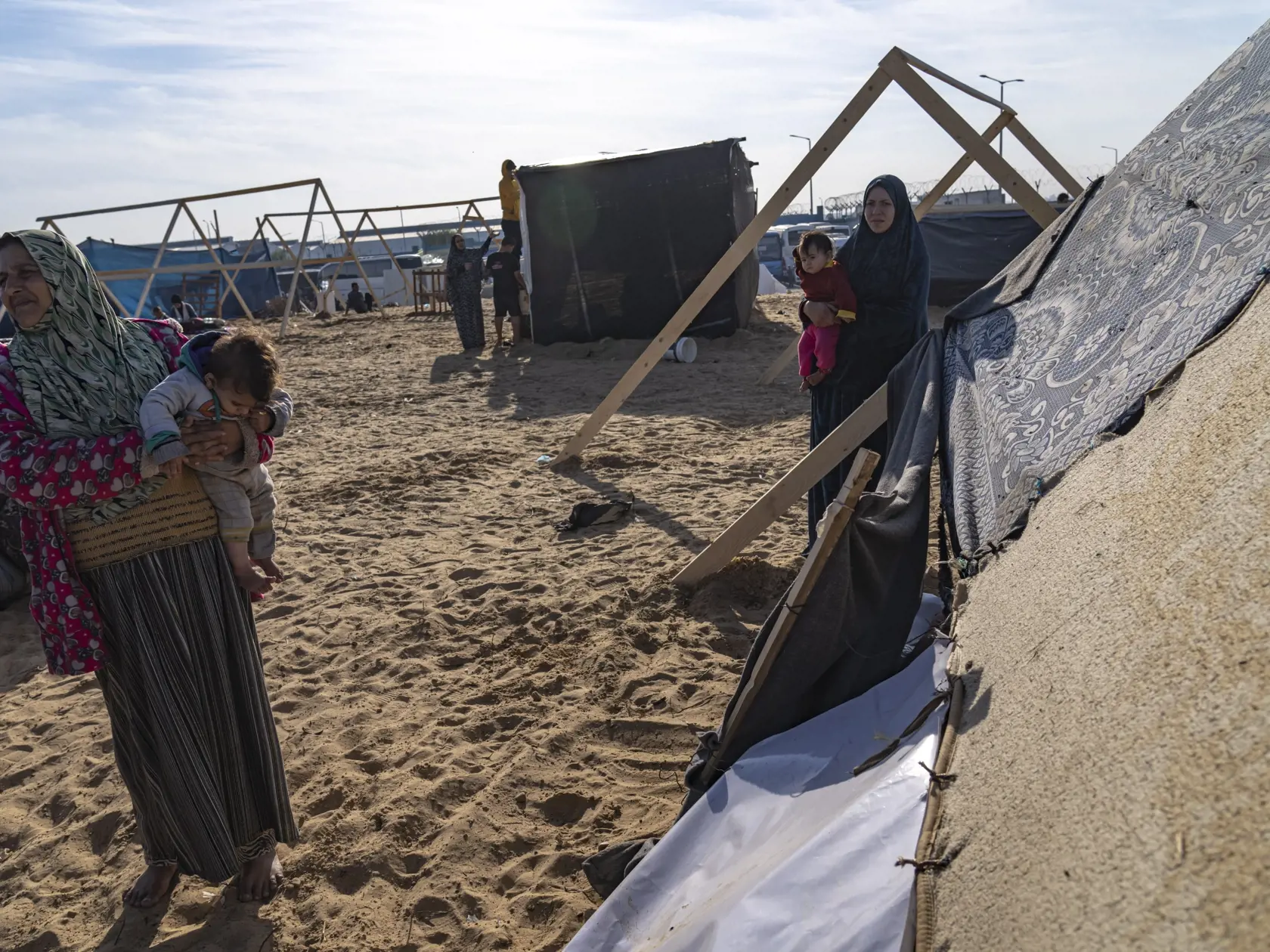 Obyvateľky Pásma Gazy, ktoré opustili v dôsledku vojny Izraela s militantným hnutím Hamas svoje domovy a presídlili sa na iné miesto v rámci enklávy, stoja pri stane v utečeneckom tábore v meste Rafah na juhu Pásma Gazy v pondelok 4. decembra 2023.