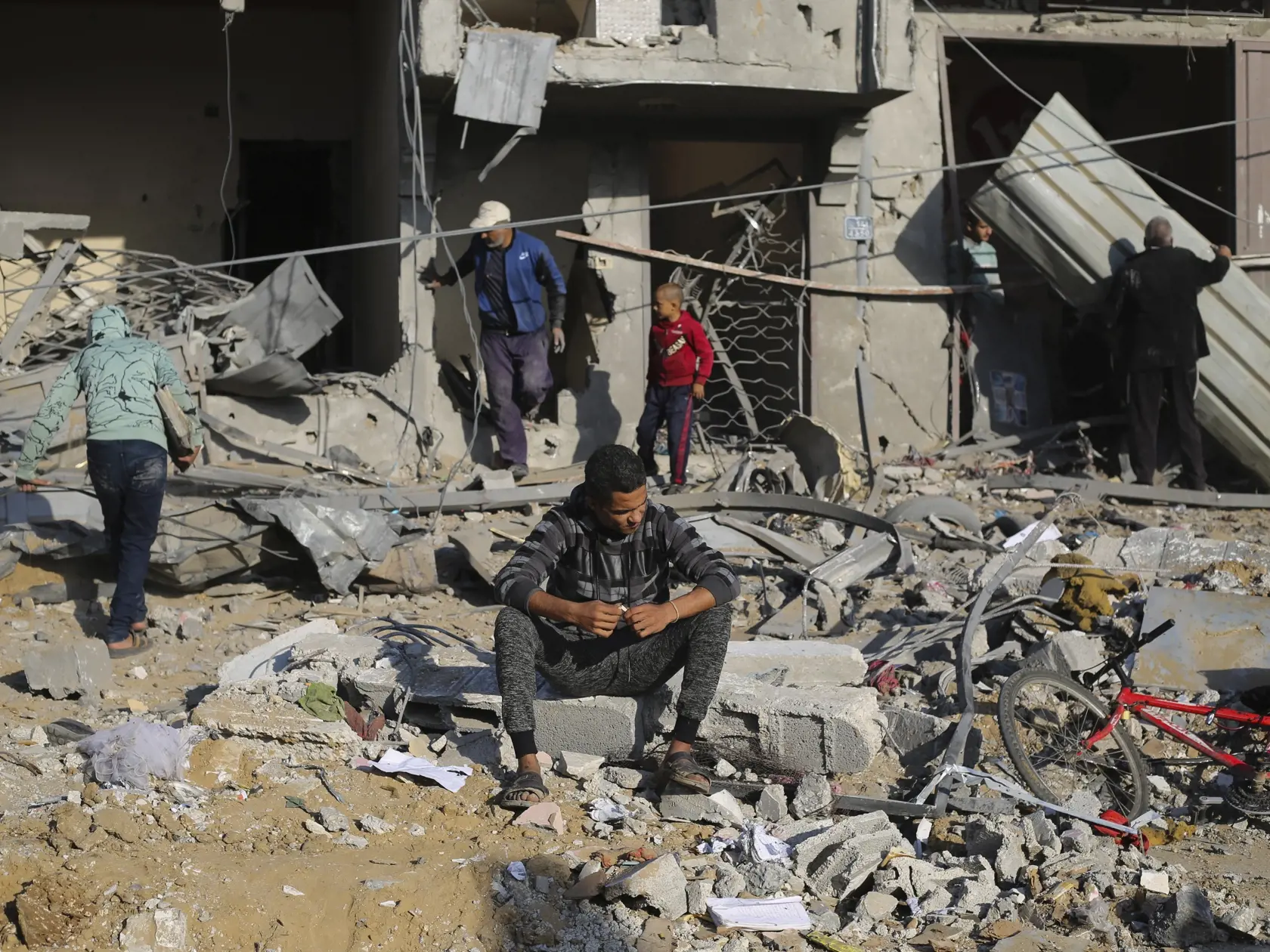 Palestínčania sa pozerajú na škody po  izraelskom leteckom útoku v meste Rafah na juhu Pásma Gazy v pondelok 4. decembra 2023.