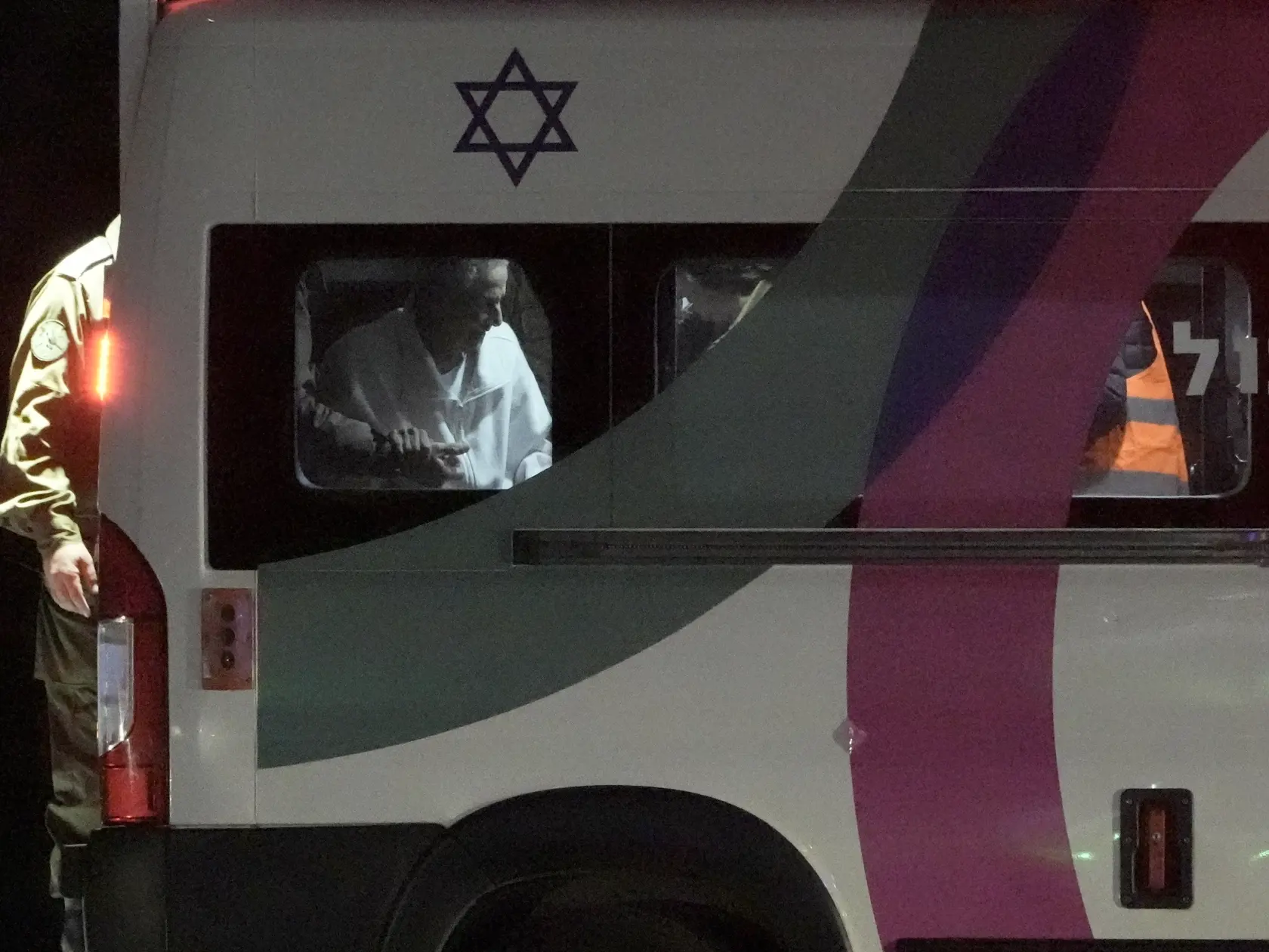 Starší muž dostáva pomoc pri nastupovaní v mini-buse počas transportu izraelských rukojemníkov prepustených militantmi Hamasu v zdravotnom stredisku Šeba v izraelskom meste Ramat Gan 28. novembra 2023.