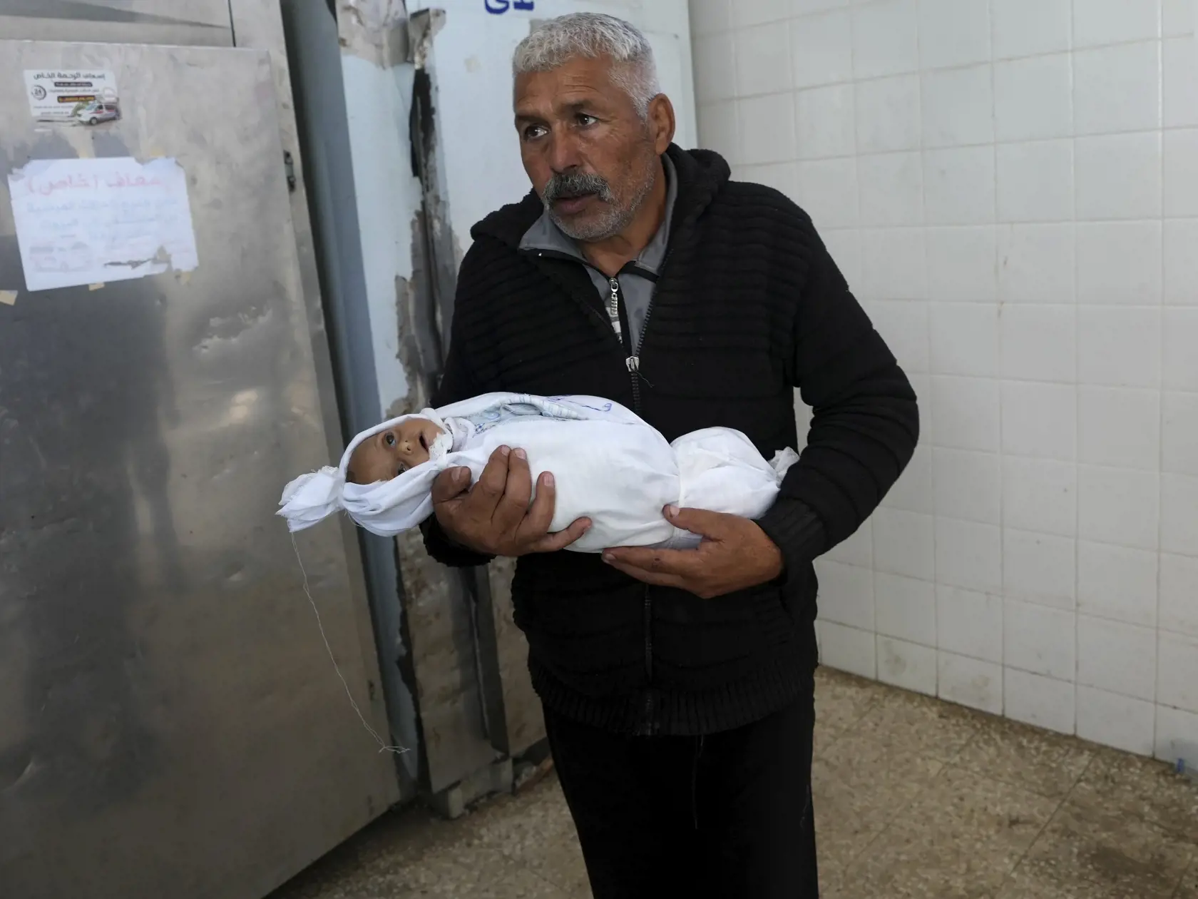 Palestínčan prináša telo svojho malého vnuka, ktorý prišiel o život pri izraelskom leteckom útoku do márnice v meste Dajr al-Balah v Pásme Gaza v piatok 1. decembra 2023.