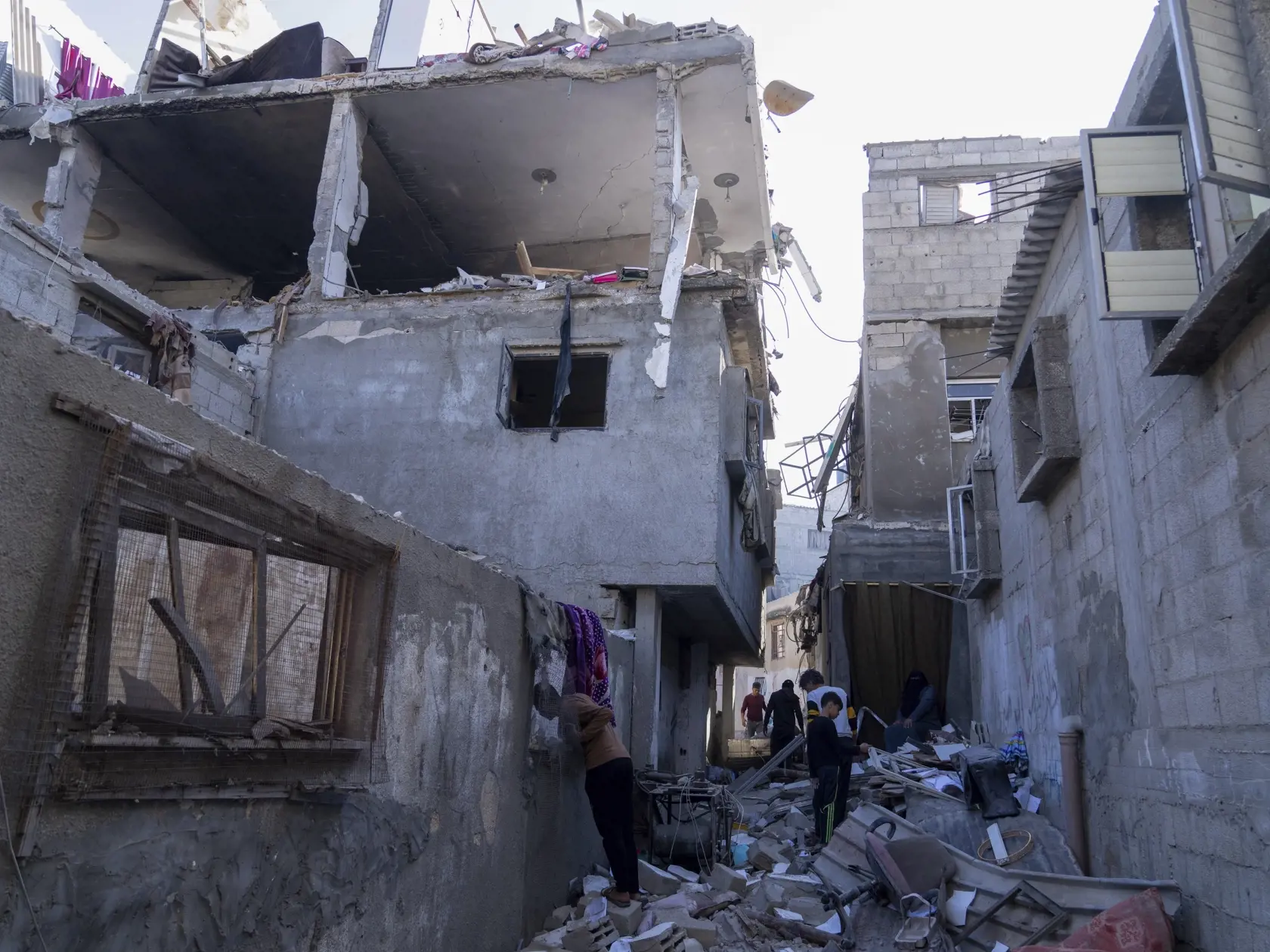 Palestínčania skúmajú poškodenú budovu po izraelskom leteckom útoku na pásmo Gazy v meste Chán Júnis, na juhu pásma Gazy 3. decembra 2023.