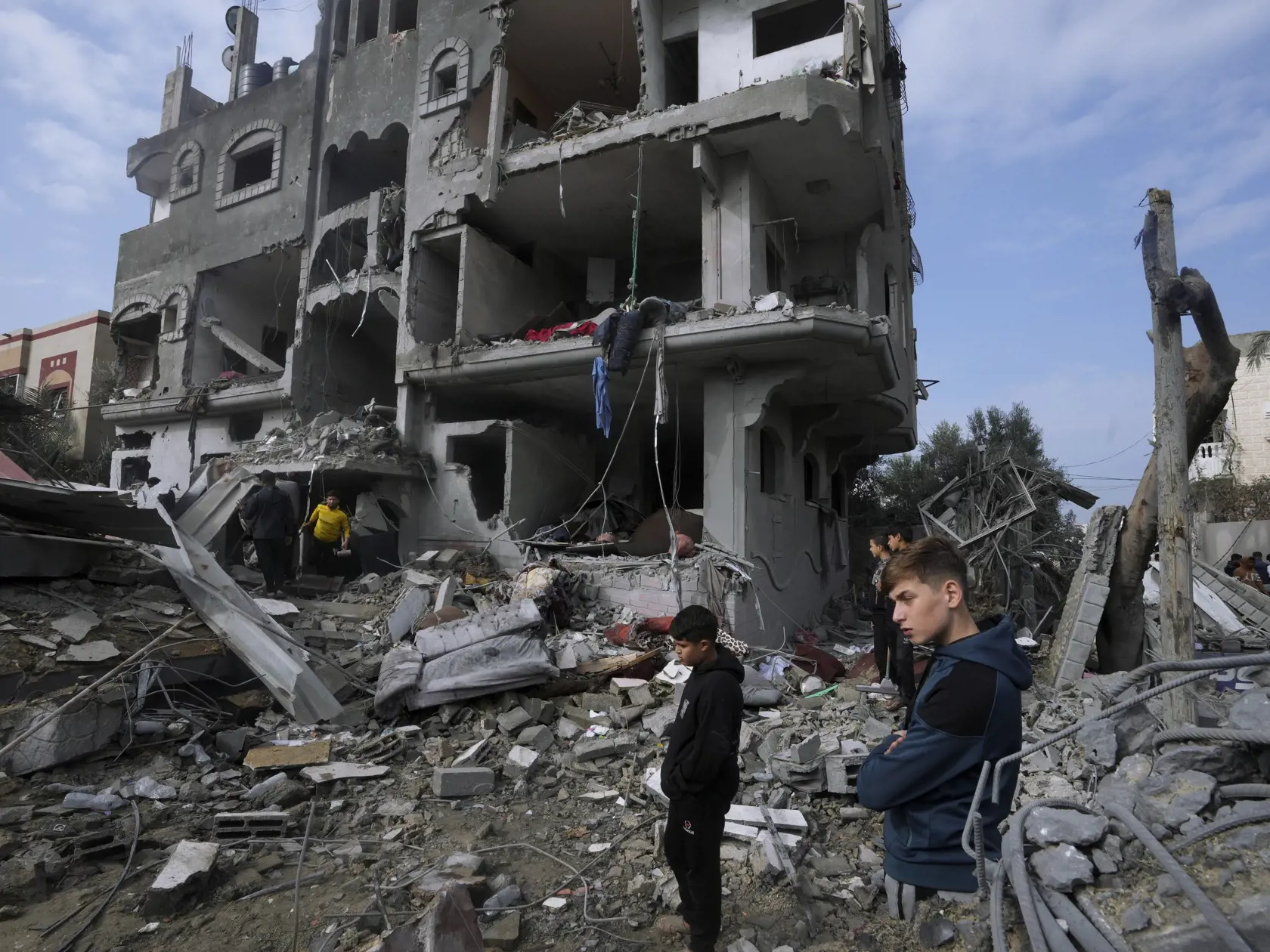 Palestínčania prehľadávajú trosky zničenej obytnej budovy, ktorá patrila rodine Al Nawasrah po izraelskom leteckom útoku na pásmo Gazy v utečeneckom tábore v meste Maghazi, v centrálnom pásme Gazy 25. decembra 2023.