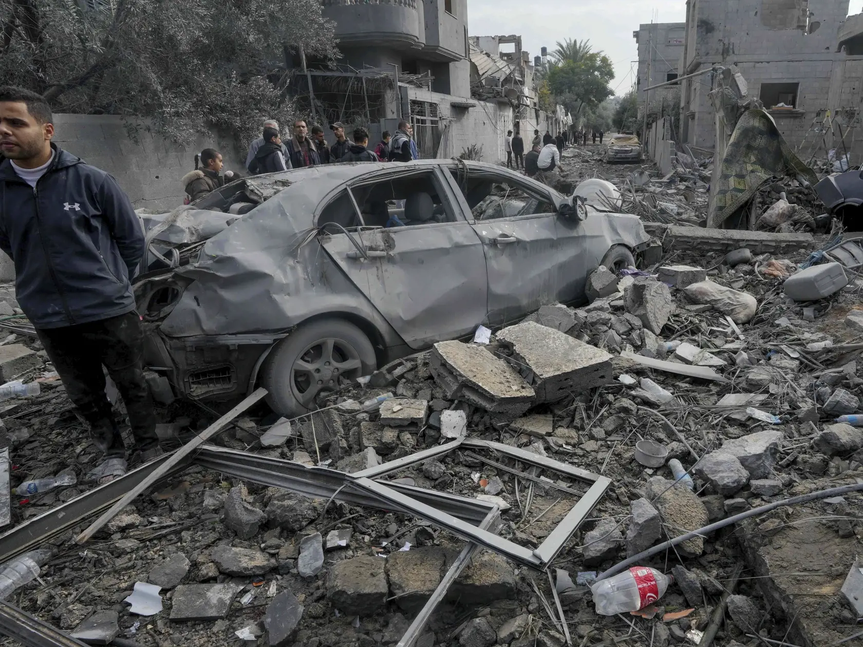 Palestínčania prehľadávajú trosky zničenej obytnej budovy, ktorá patrila rodine Al Nawasrah po izraelskom leteckom útoku na pásmo Gazy v utečeneckom tábore v meste Maghazi, v centrálnom pásme Gazy 25. decembra 2023.