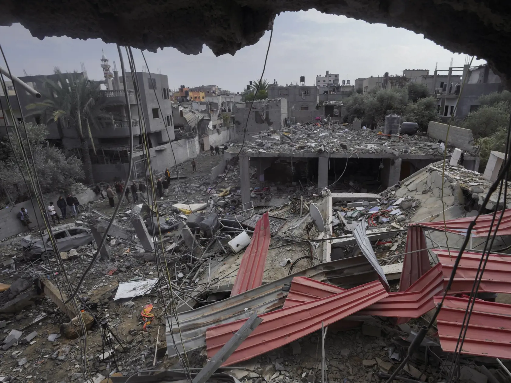 Palestínčania prehľadávajú trosky zničenej obytnej budovy, ktorá patrila rodine Al Nawasrah po izraelskom leteckom útoku na pásmo Gazy v utečeneckom tábore v meste Maghazi, v centrálnom pásme Gazy 25. decembra 2023.