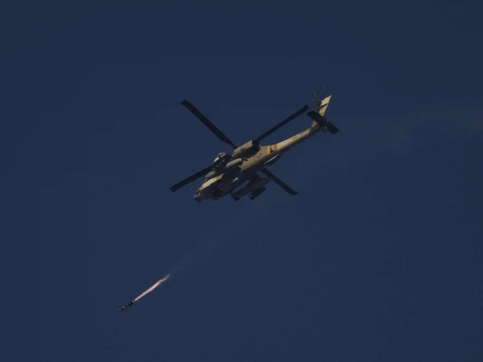Izraelský vojenský vrtuľník Apache strieľa raketu smerom na pásmo Gazy, čo je viditeľné z juhu Izraela 25. decembra 2023.