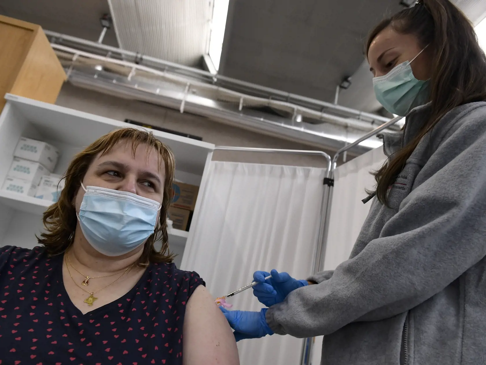 Žena dostáva vakcínu od spoločnosti Pfizer-Biontech počas očkovania proti ochoreniu COVID-19 vo vakcinačnom centre.