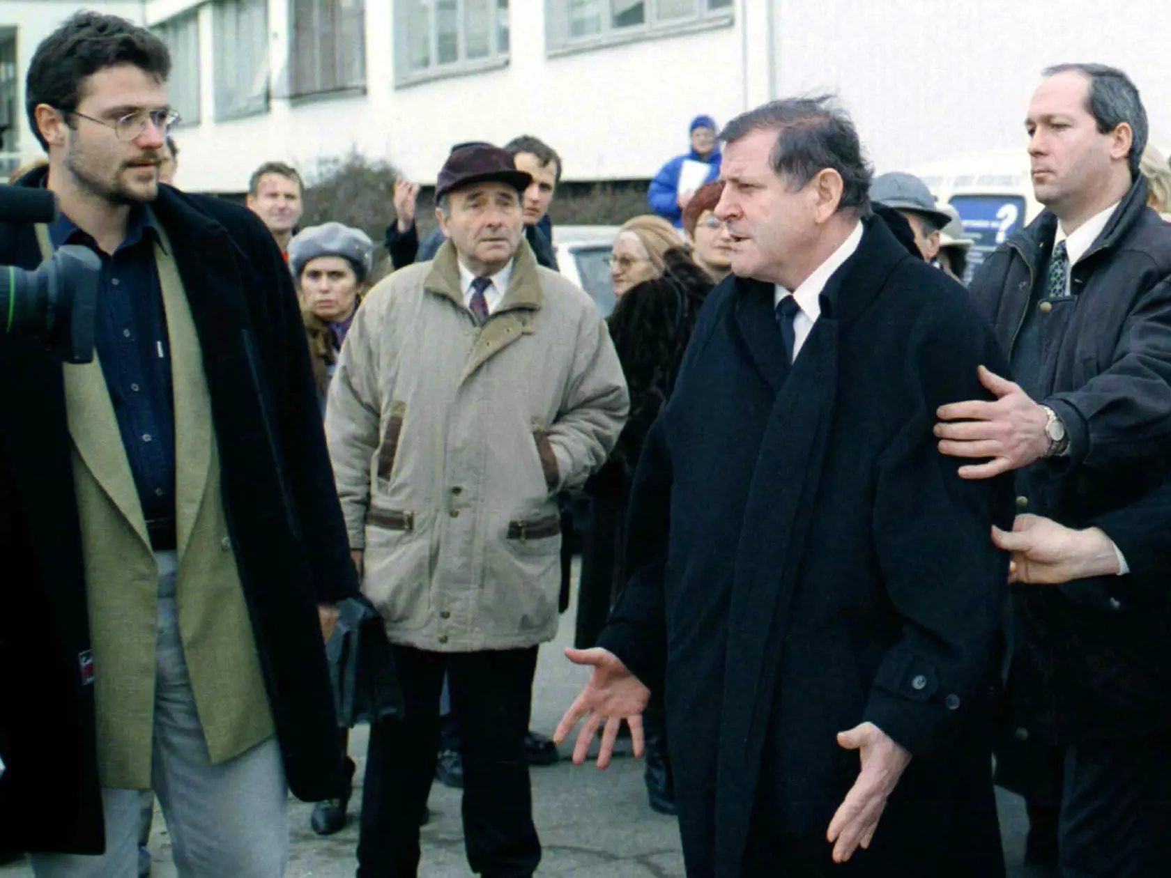 Nahnevaného bývalého slovenského premiéra Vladimíra Mečiara (2.zprava) držia bodyguardi keď slovne napadol televízne štáby na pohrebe bývalého ministra jeho vlády Jána Duckého 15. januára 1999 v Bratislave.