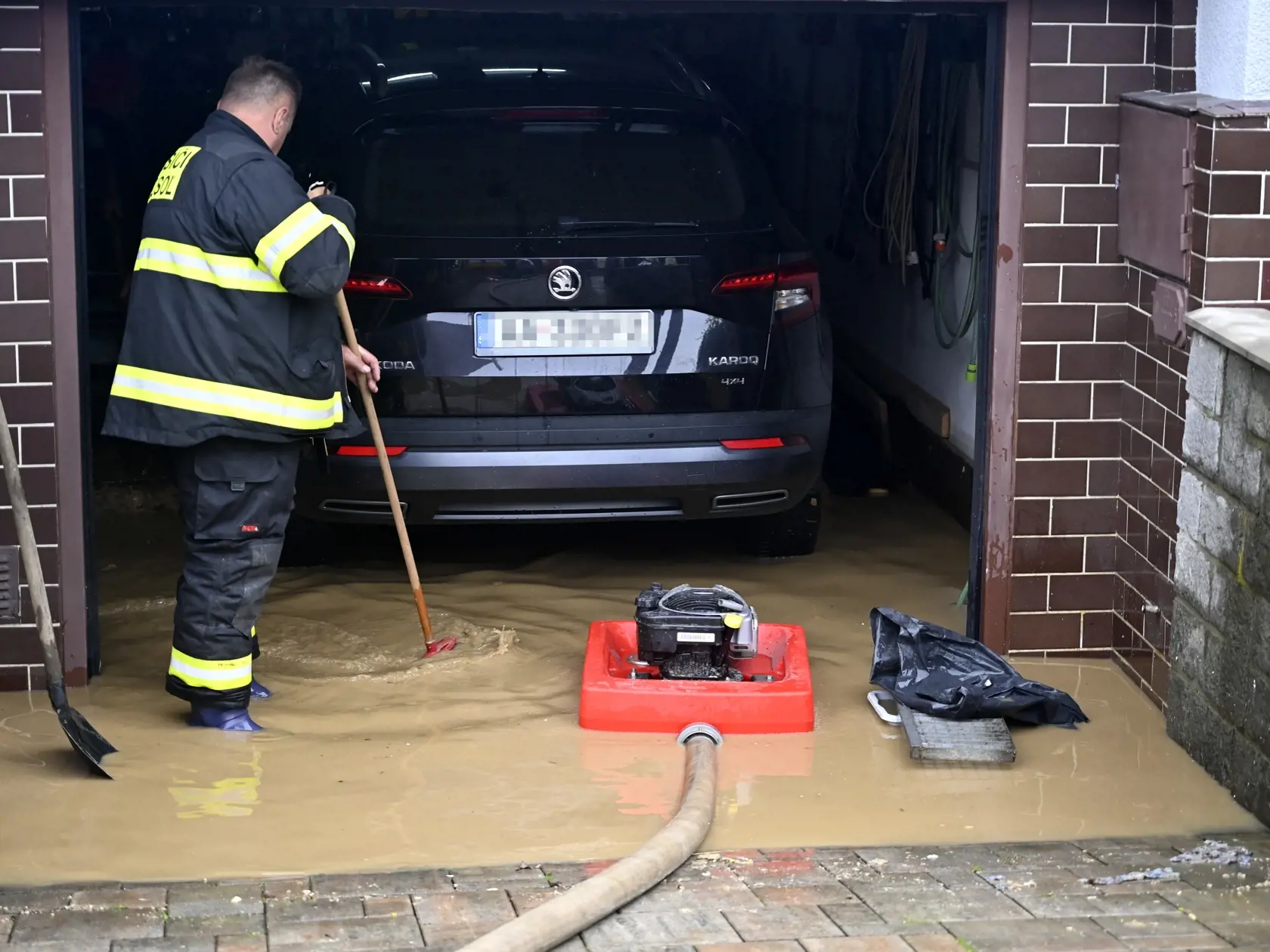 Vo Vranove nad Topľou vyhlásili začiatkom júna tretí stupeň povodňovej aktivity. Na snímke hasič odčerpáva vodu z pivnice rodinného domu po bleskovej povodni vo Vranove nad Topľou, časť Čemerné v utorok 4. júna 2024.