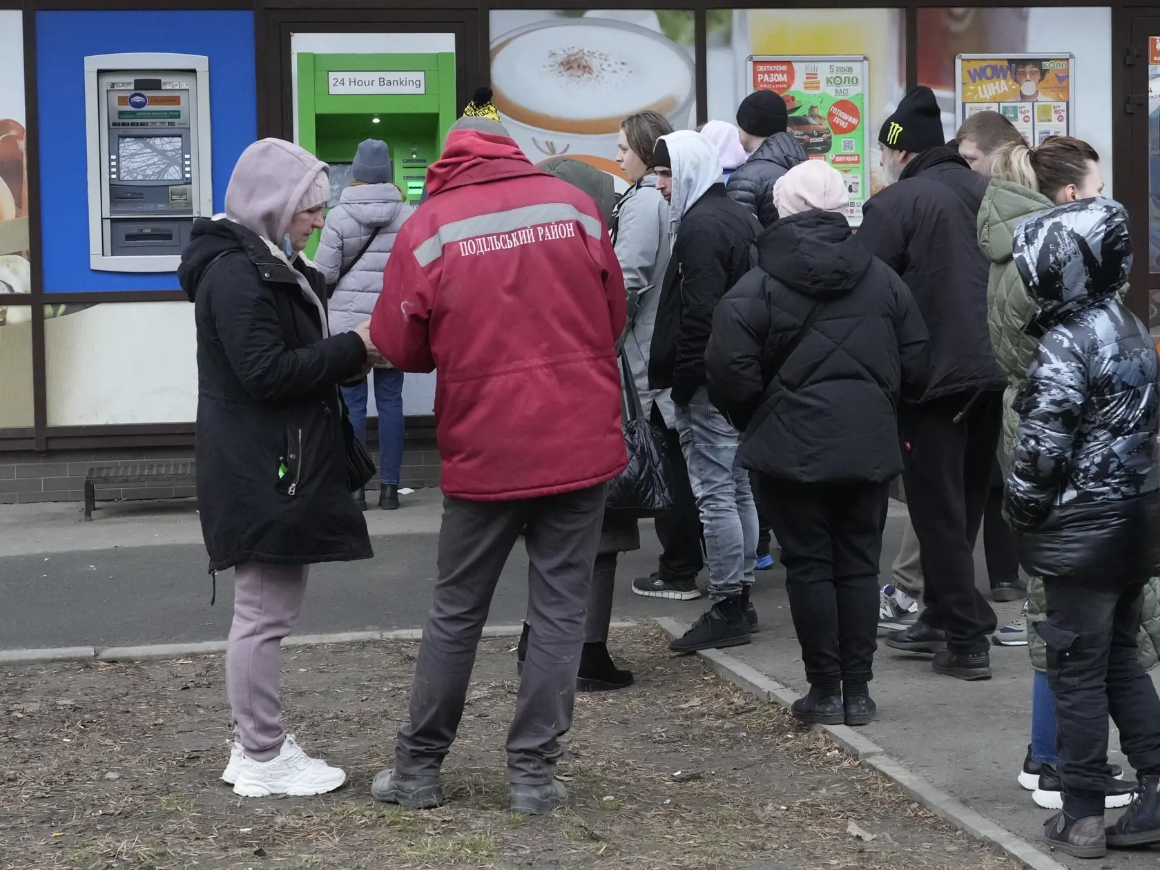 Ľudia čakajú pred bankomatom, aby si vybrali peniaze v Kyjeve.