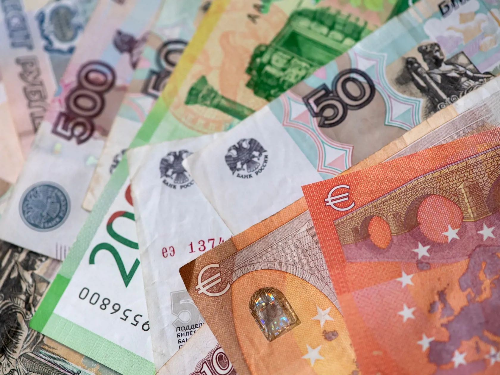 WA 27 Mníchov - Bankovky rubľa a eurové bankovky sú na stole v Mníchove v pondelok 28. februára 2022. Rubeľ sa v pondelok prepadol na rekordné minimum a dolár oproti väčšine mien prudko vzrástol po tom, ako západné štáty oznámili nové sankcie na potrestanie Ruska za jeho inváziu na Ukrajinu a prezident Vladimir Putin uviedol svoje jadrové sily do stavu najvyššej pohotovosti. FOTO TASR/DPA