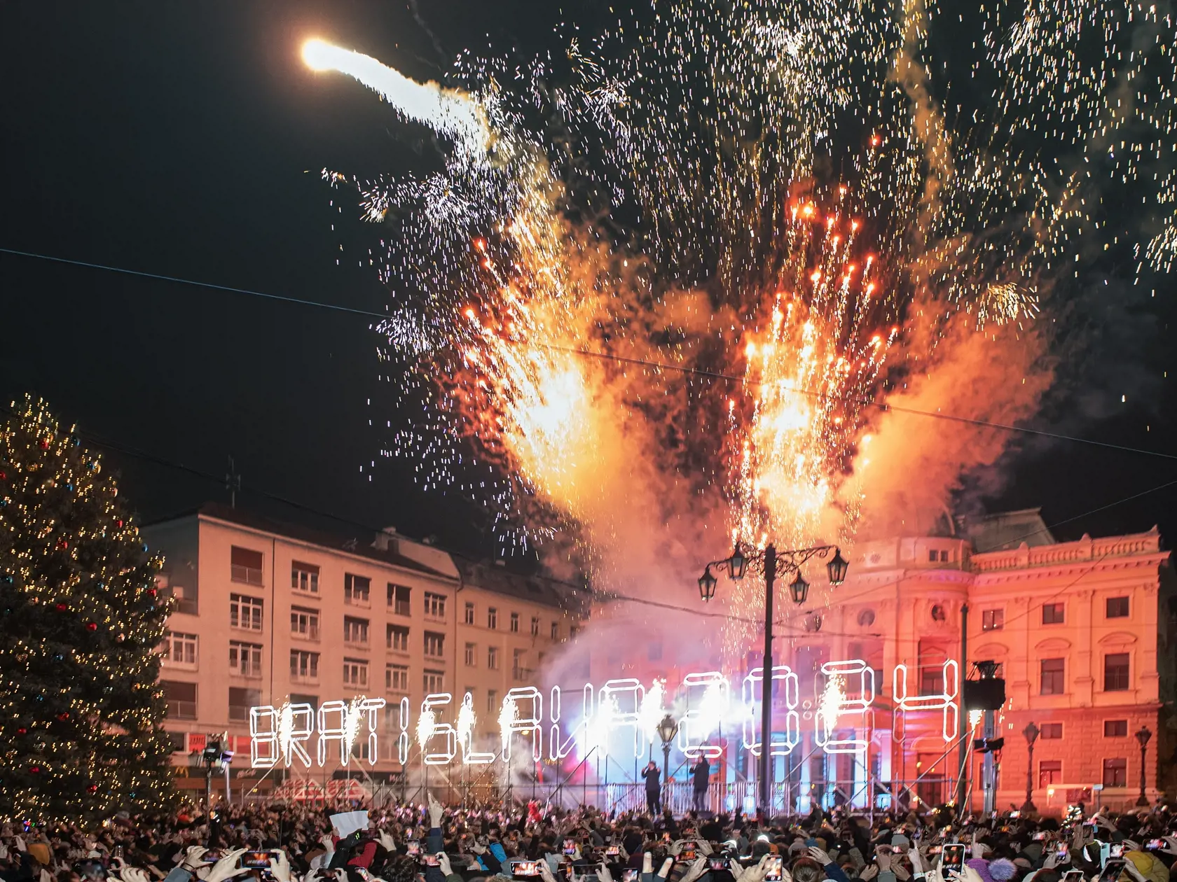 Na snímke ľudia oslavujú príchod Nového roka 2024 na Hviezdoslavovom námestí 1. januára 2024 v Bratislave. FOTO TASR - Pavel Neubauer 
