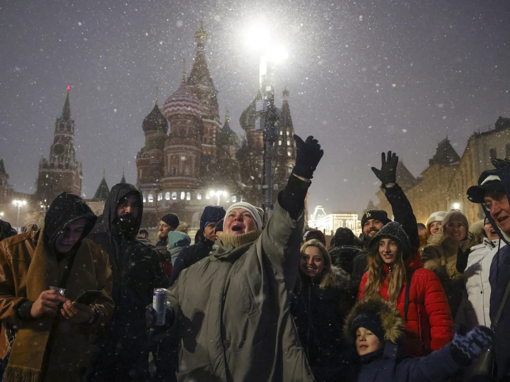 KK31 Moskva - Ľudia sa zhromažďujú neďaleko Červeného námestia počas novoročných osláv v Moskve 1. januára 2024. FOTO TASR/AP
People gather near Red Square with the St. Basil's Cathedral, right, and the Spasskaya Tower, left, in the background, to celebrate the new year after midnight in Moscow, Russia, Monday, Jan. 1, 2024. (AP Photo/Marina Lystseva)
