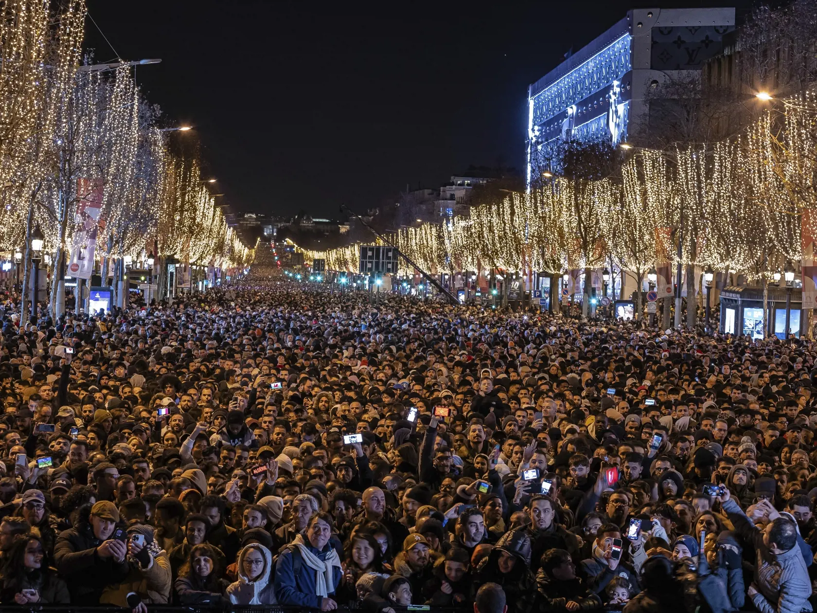 KK32 Paríž - Ľudia sledujú svetelnú šou premietanú na Víťaznom oblúku v rámci silvestrovských osláv príchodu Nového roka na bulvári Champs-Élysées v Paríži 31. decembra 2023 v Paríži. FOTO TASR/AP
People watch a light show projected on the Arc de Triomphe as they celebrate New Year's on the Champs Elysees in Paris, France, Sunday, Dec. 31, 2023. (AP Photo/Aurelien Morissard)