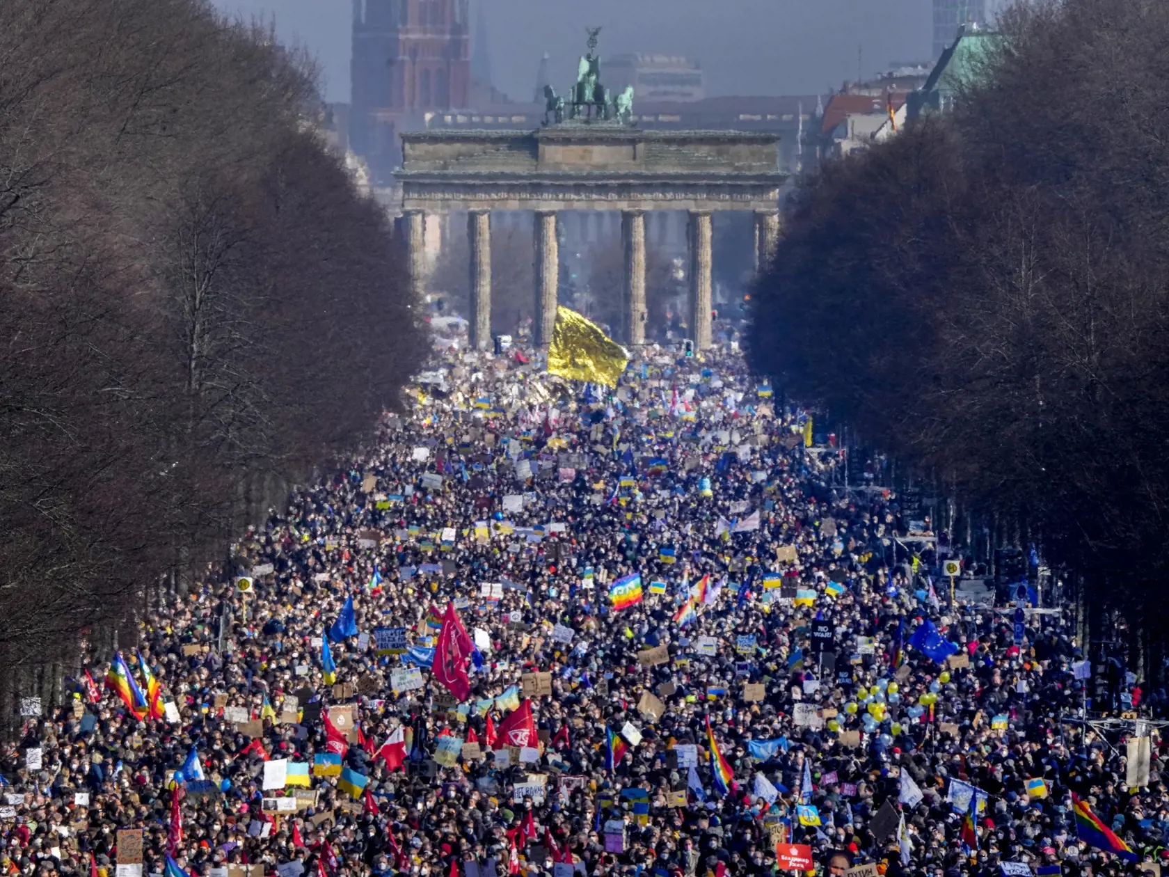 KK61 Berlín - Ľudia kráčajú po Ulici 17. júna pred zhromaždením proti ruskej invázii na Ukrajine, 27. februára 2022 v Berlíne. FOTO TASR/AP 
People walk down the bulevard 'Strasse des 17. Juni' ahead of a rally against Russia's invasion of Ukraine in Berlin, Germany, Sunday, Feb. 27, 2022. (AP Photo/Markus Schreiber)