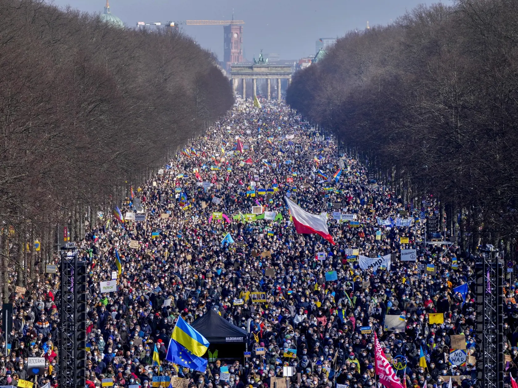KK63 Berlín - Ľudia kráčajú po Ulici 17. júna pred zhromaždením proti ruskej invázii na Ukrajine, 27. februára 2022 v Berlíne. FOTO TASR/AP 
People walk down the bulevard 'Strasse des 17. Juni' ahead of a rally against Russia's invasion of Ukraine in Berlin, Germany, Sunday, Feb. 27, 2022. (AP Photo/Markus Schreiber)