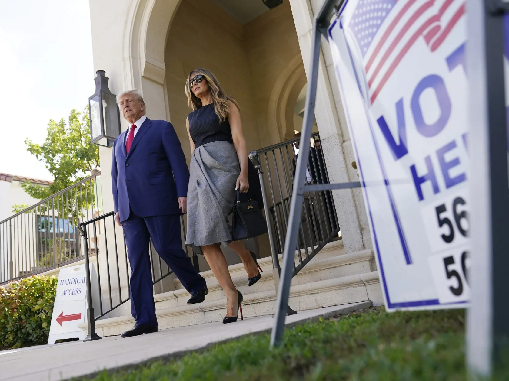 Bývalý americký prezident Donald Trump a jeho manželka Melania Trumpová vychádzajú z volebnej miestnosti v Palm Beach na Floride počas volieb do oboch komôr Kongresu v utorok 8. novembra 2022.