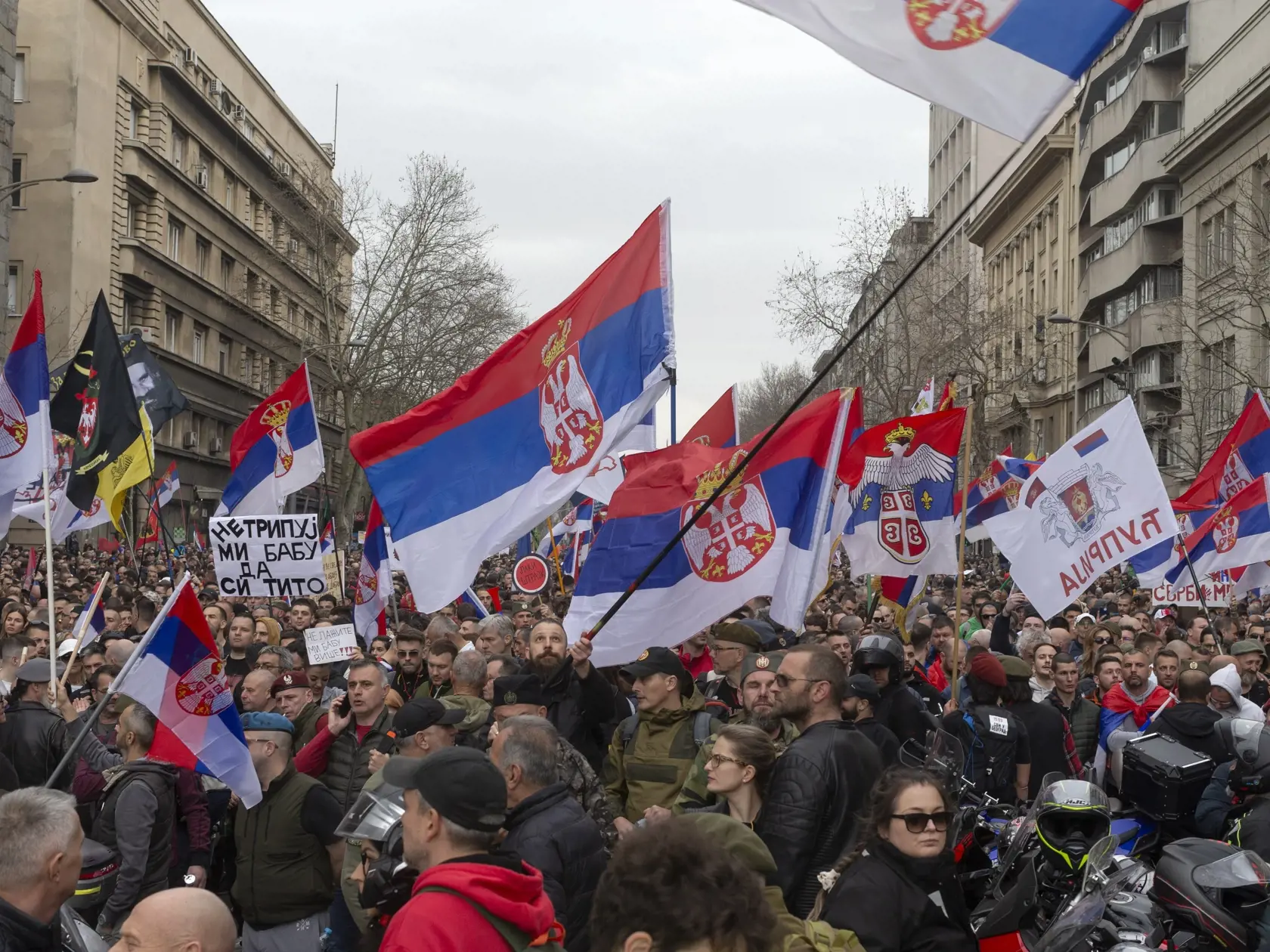Demonštranti blokujú ulicu a mávajú srbskými zástavami počas veľkého protikorupčného zhromaždenia vedeného univerzitnými študentmi v Belehrade 15. marca 2025.