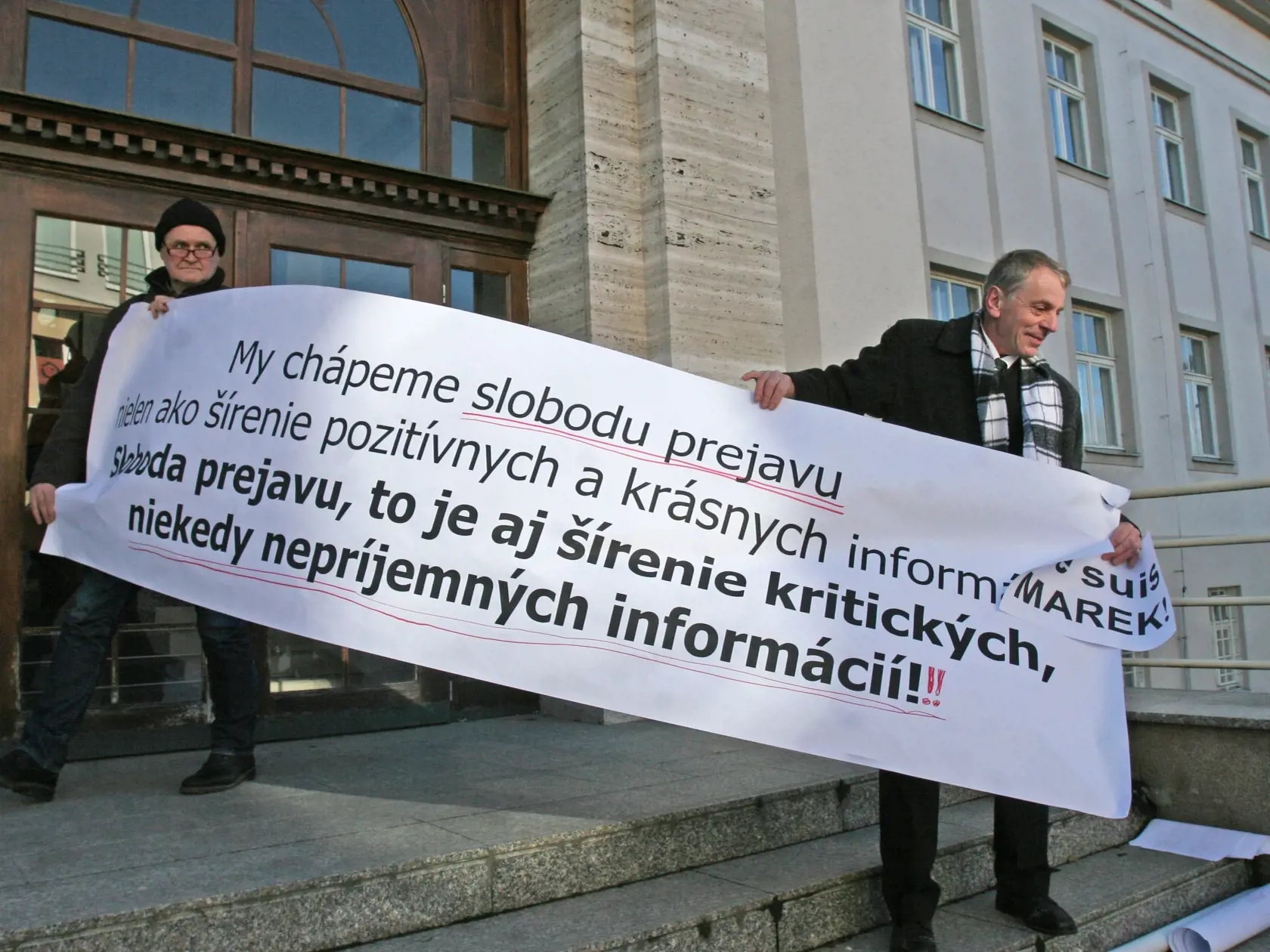 Marekovi priatelia s transparentmi pred budovou okresného súdu v Prievidzi.