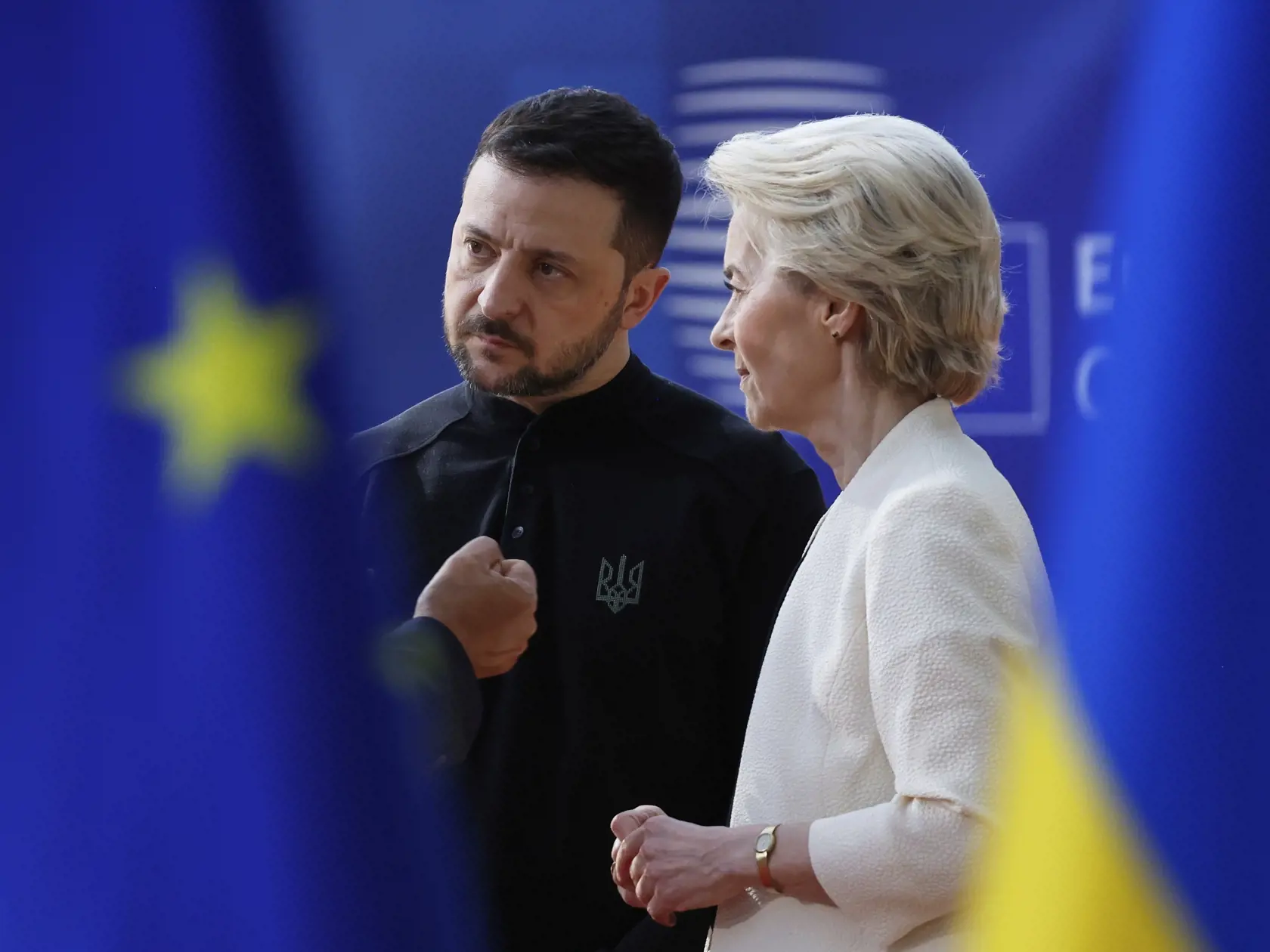 Predsedníčka Európskej komisie Ursula von der Leyenová (vpravo) a ukrajinský prezident Volodymyr Zelenskyj (vľavo) sa rozprávajú s predsedom Európskej rady Antóniom Costom (skrytý za zástavou Európskej únie) počas rokovania za okrúhlym stolom na mimoriadnom summite EÚ v sídle Európskej rady v Bruseli 6. marca 2025.