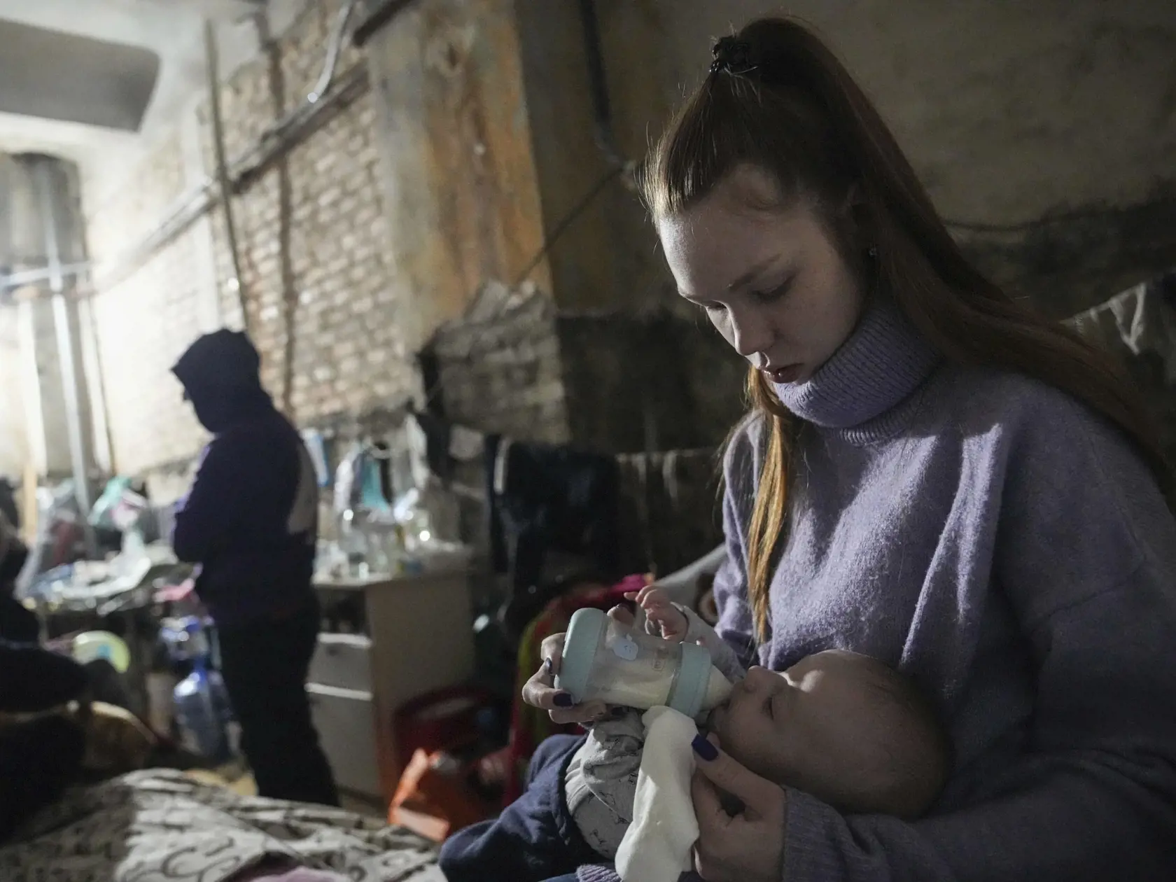 WA 51 Mariupol - Mladá mamička dáva svojmu dieťaťu sunár z kojeneckej fľaše v improvizovanom protileteckom kryte v Mariupole počas dvanásteho dňa ruskej invázie na Ukrajine v pondelok 7. marca 2022. FOTO TASR/AP  

A young woman feeds a baby in the improvised bomb shelter in Mariupol, Ukraine, Monday, March 7, 2022. (AP Photo/Evgeniy Maloletka)