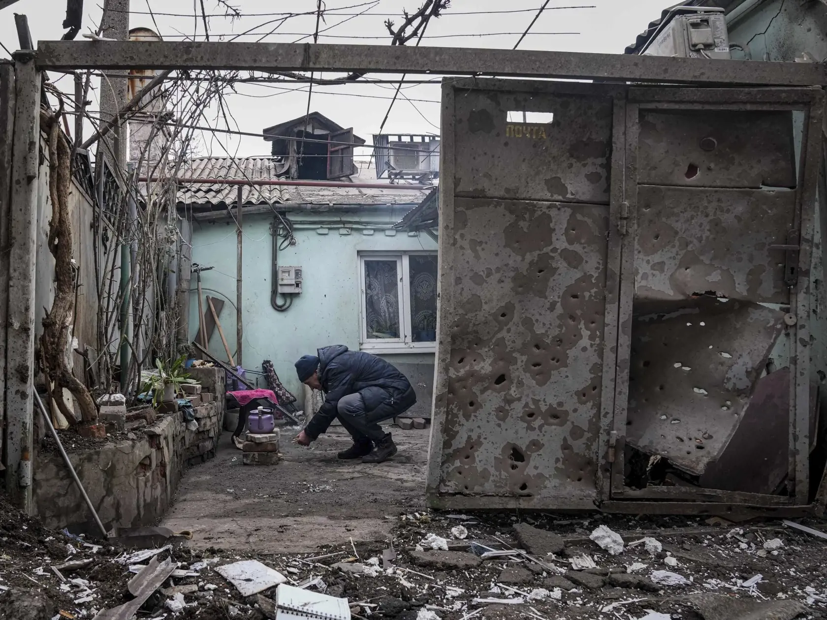 WA 48 Mariupol - Muž zapaľuje oheň na čaj na dvore zničeného rodinného domu po ostreľovaní v Mariupole počas dvanásteho dňa ruskej invázie na Ukrajine v pondelok 7. marca 2022. FOTO TASR/AP  

A man lights a fire under the kettle in a yard of an apartment building hit by shelling in Mariupol, Ukraine, Monday, March 7, 2022. (AP Photo/Evgeniy Maloletka)