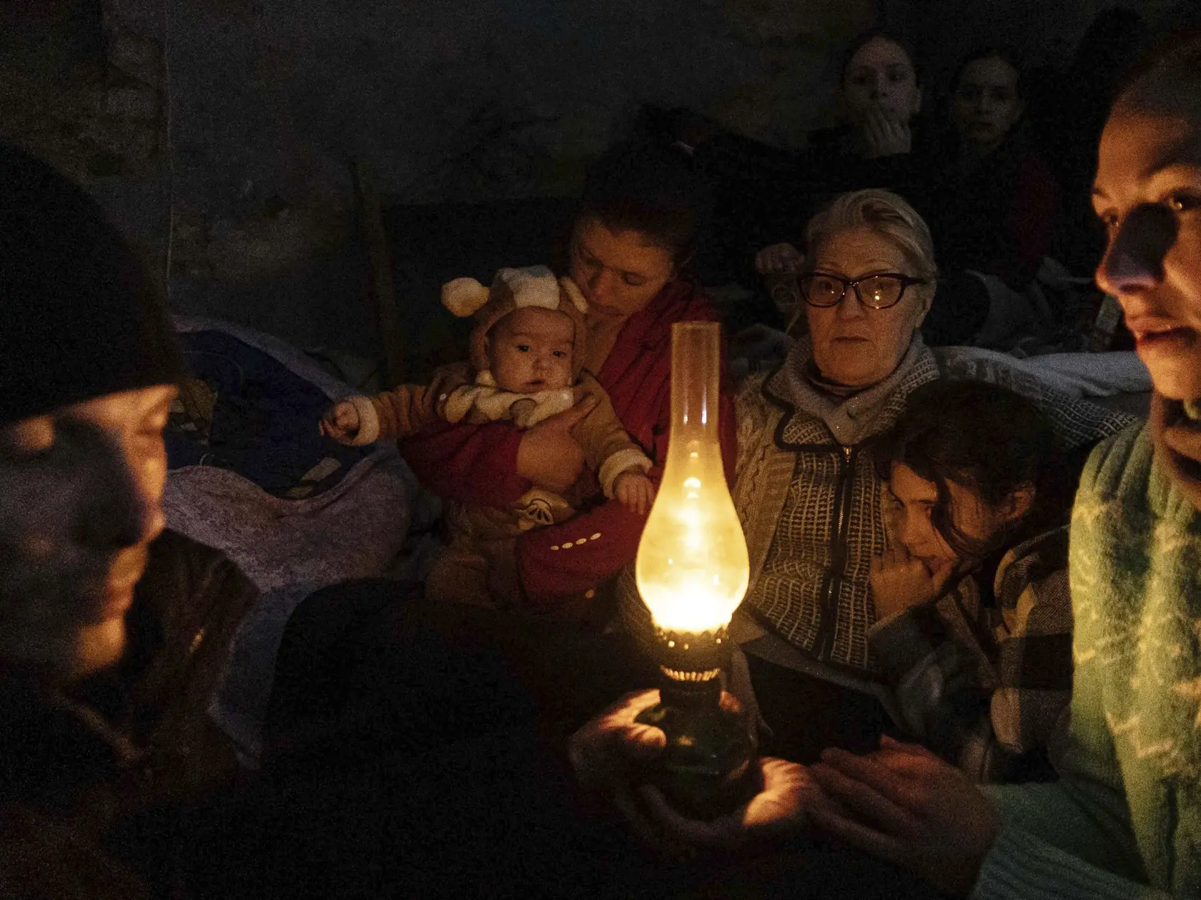 WA 49 Mariupol - Ľudia sedia okolo lampy v protileteckom kryte v Mariupole počas jedenásteho dňa ruskej invázie na Ukrajine v nedeľu 6. marca 2022. FOTO TASR/AP  

People sit around a lamp in a bomb shelter in Mariupol, Ukraine, Sunday, March 6, 2022. (AP Photo/Evgeniy Maloletka)