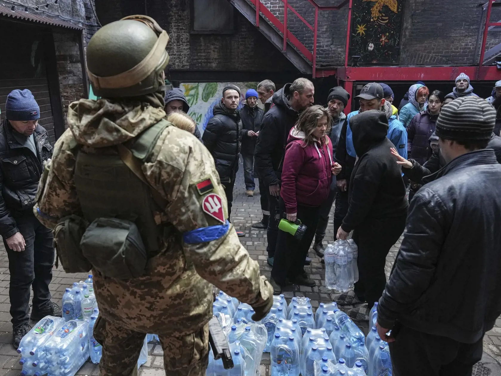 KK18 Mariupol - Ukrajinskí vojaci rozdávajú vodu pre ľudí v Mariupole počas jedenásteho dňa ruskej invázie na Ukrajine v nedeľu 6. marca 2022. FOTO TASR/AP  

Ukrainian servicemen, center, distributes water to people in Mariupol, Ukraine, Sunday, March 6, 2022. (AP Photo/Evgeniy Maloletka)