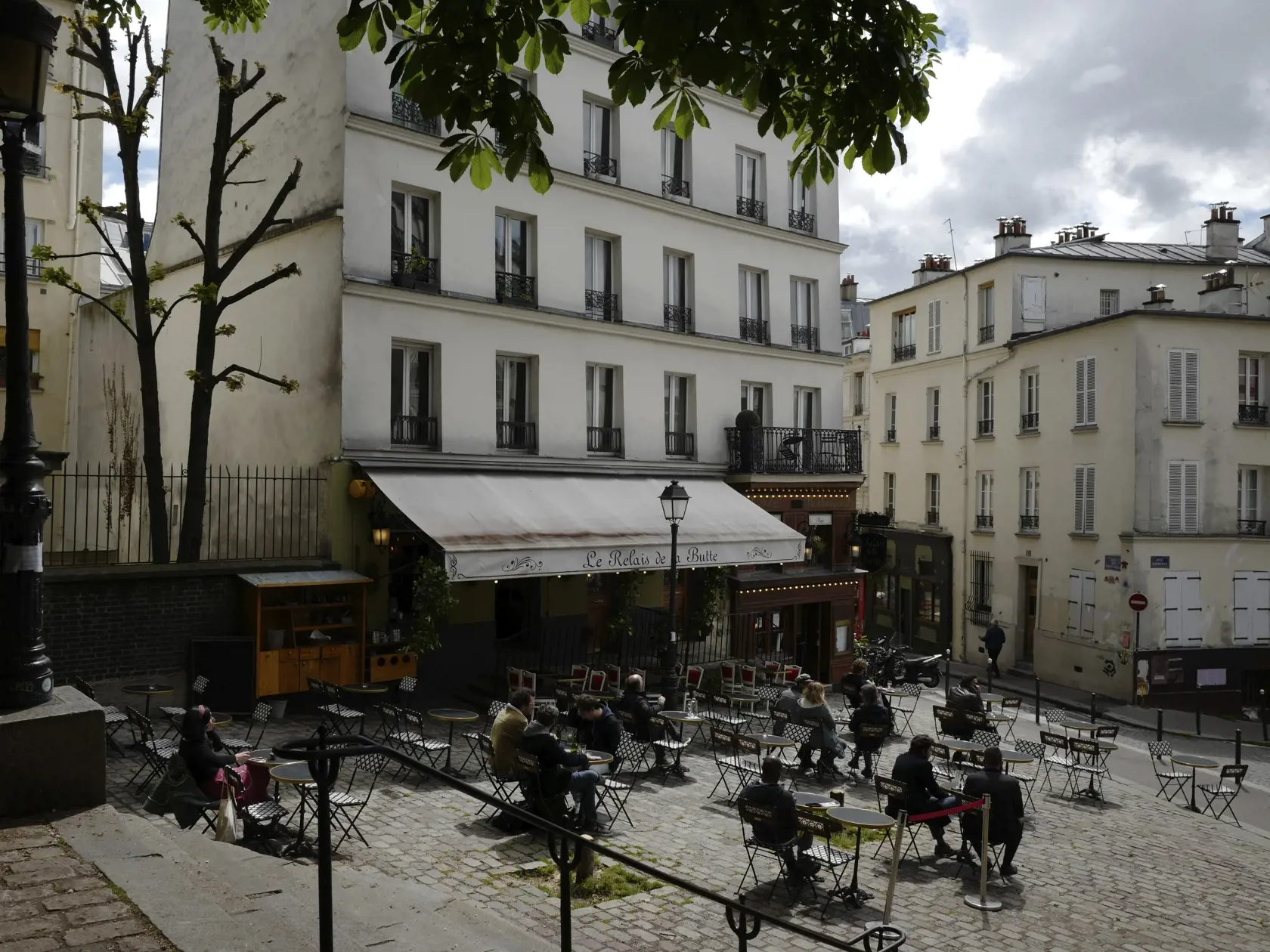 Zákazníci popíjajú kávu na letnej terase reštaurácie po jej znovuotvorení v Paríži.