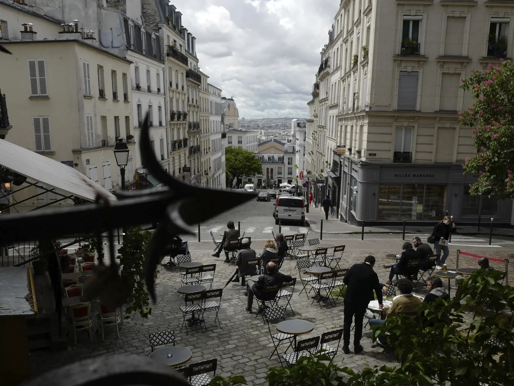 Zákazníci popíjajú kávu na letnej terase reštaurácie po jej znovuotvorení v Paríži.