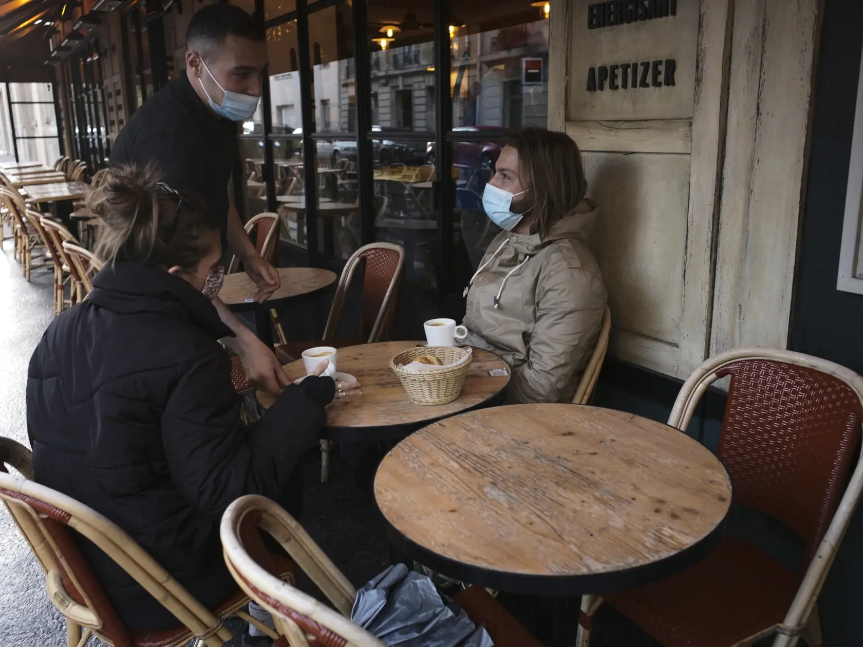 Zákazníci popíjajú kávu na letnej terase reštaurácie po jej znovuotvorení v Paríži.