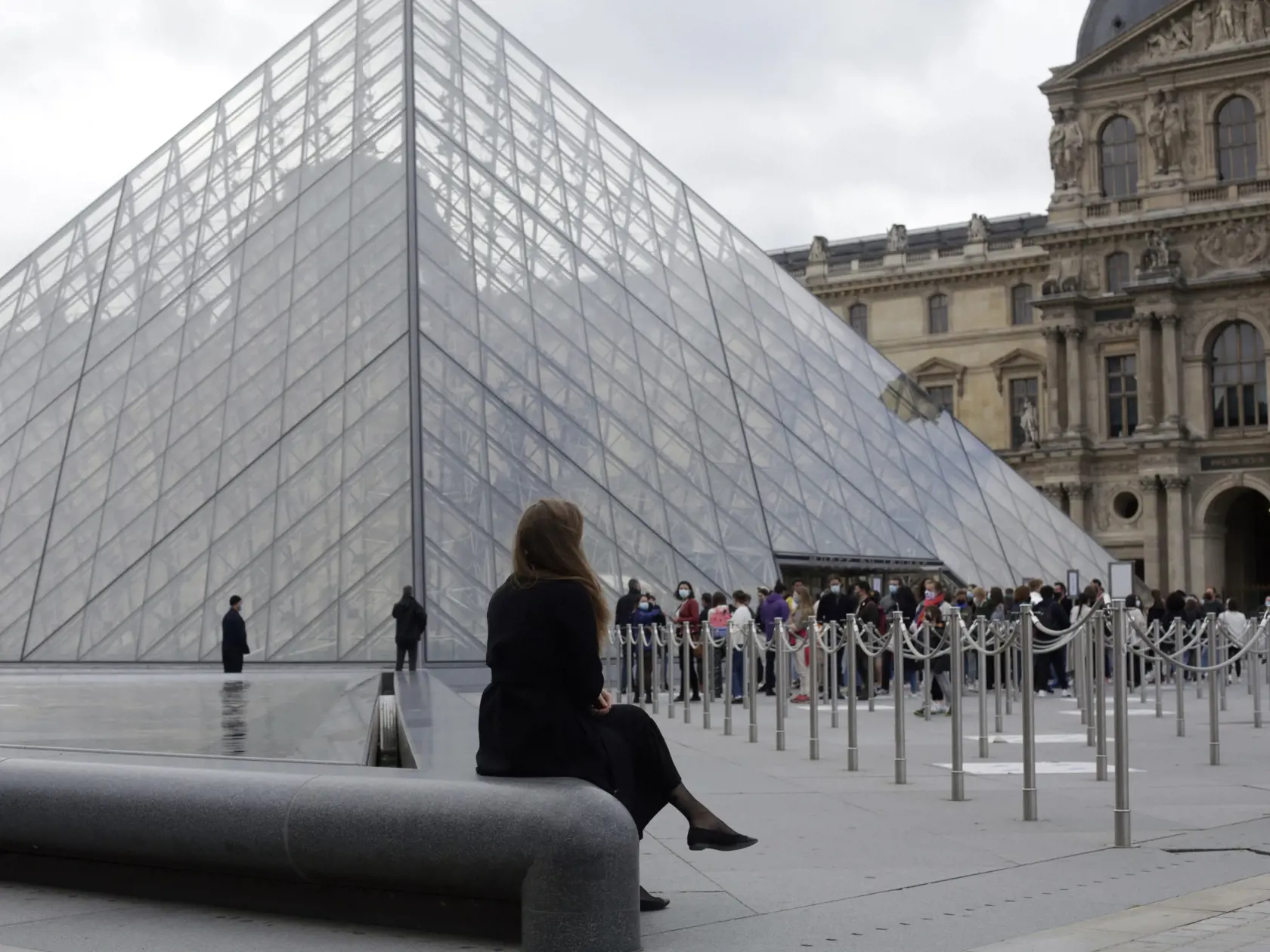 Ľudia stoja v rade pred Múzeom Louvre po jeho znovuotvorení.