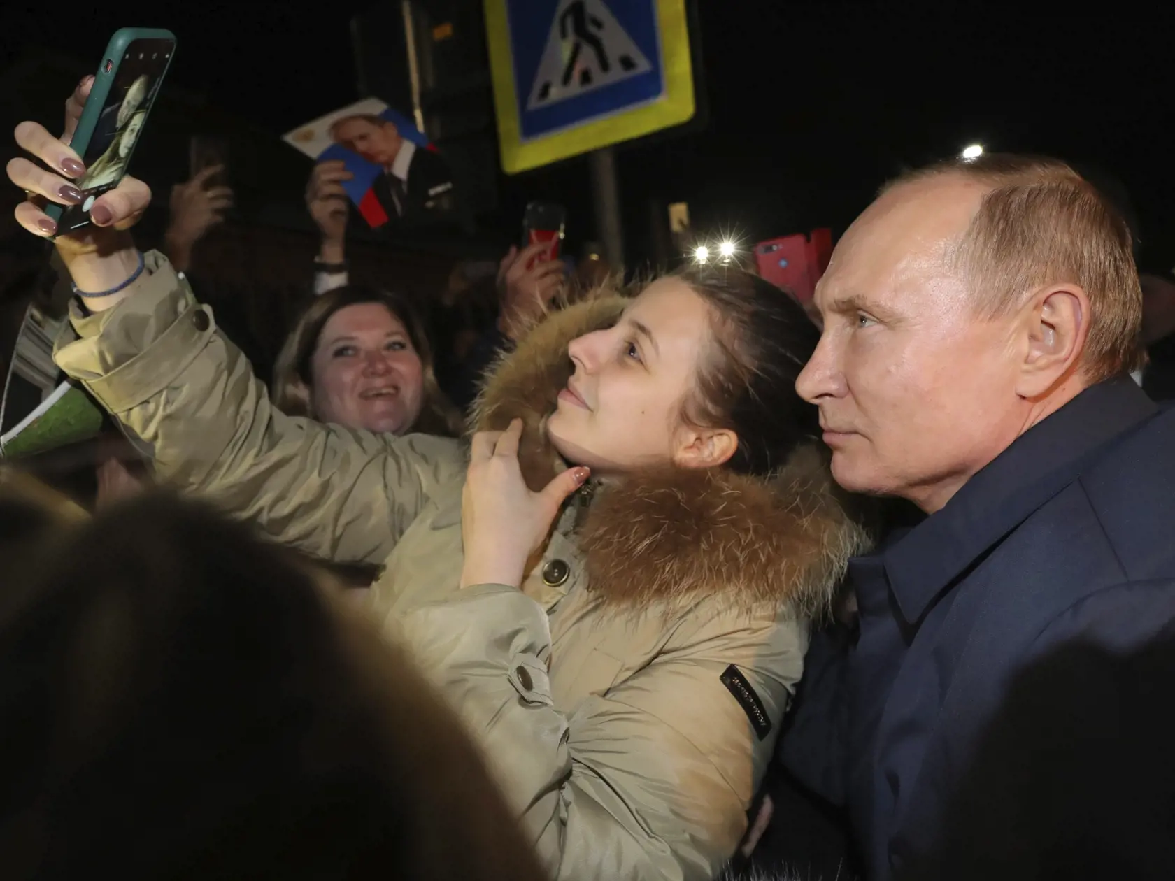 JB 22 Enem - Ruský prezident Vladimir Putin (vpravo) pózuje pre selfie počas stretnutia s ľuďmi v ruskej dedine Enem, 15 km juhovýchodne od Krasnodaru 23. decembra 2019. Putin v pondelok slávnostne otvoril železničnú časť Krymského mosta cez Kerčský prieliv, keď sa v motorovom vozni odviezol po trase z krymského mesta Kerč do mesta Tamaň, ktoré sa nachádza na druhej strane prielivu. FOTO TASR/AP

Russian President Vladimir Putin poses for a selfie during a meeting with people in the village of E