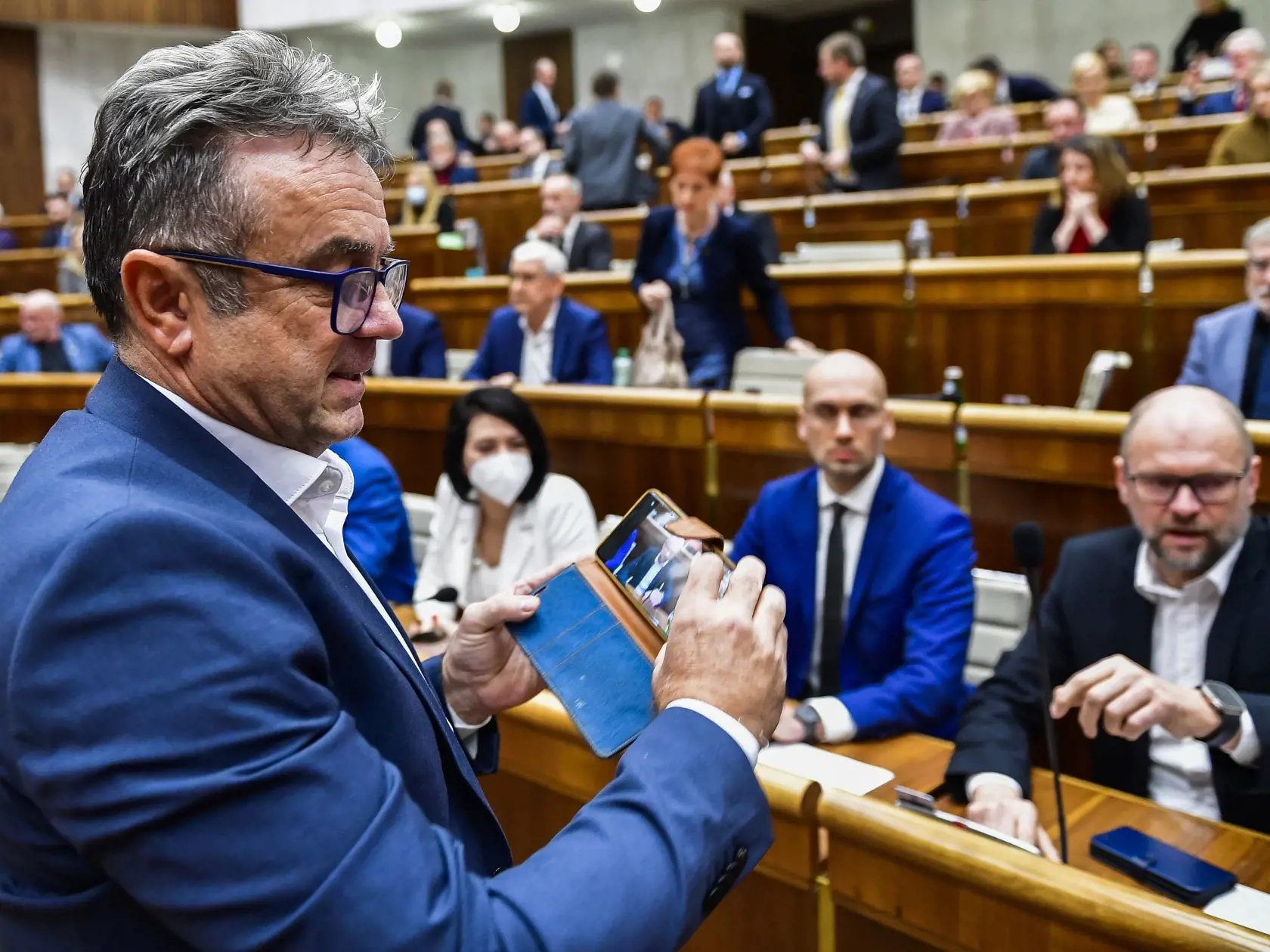 Na snímke koaličný poslanec Jozef Pročko (OĽANO) si fotí poslancov opozičnej Strany SaS po vyslovení nedôvery vláde Eduarda Hegera (OĽANO) na 78. schôdzi parlamentu v Bratislave vo štvrtok 15. decembra 2022. Národná rada (NR) SR vo štvrtok vyslovila nedôveru vláde Eduarda Hegera. Za jej pád hlasovalo 78 poslancov. FOTO TASR - Jaroslav Novák