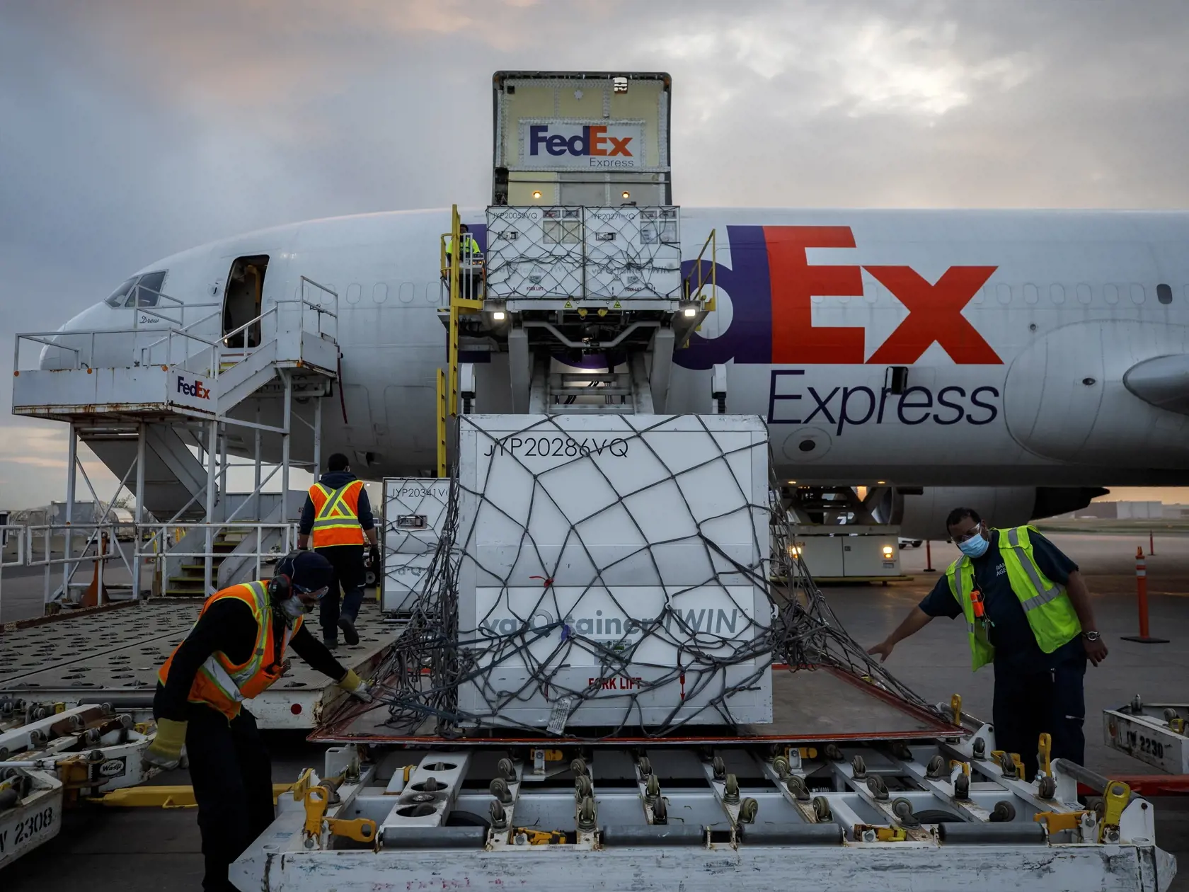 KK4 Toronto - Na snímke zamestnanci vykladajú zásielku vakcín proti ochoreniu Covid-19 od spoločnosti Moderna z lietadla americkej  zásielkovej spoločnosti FedEx  na medzinárodnom letisku v Toronte 20. apríla 2021. FOTO TASR/AP
Workers unload a shipment of the Moderna COVID-19 vaccine at the FedEx hub at Pearson International Airport in Toronto on Thursday, May 20, 2021. (Cole Burston/The Canadian Press via AP)