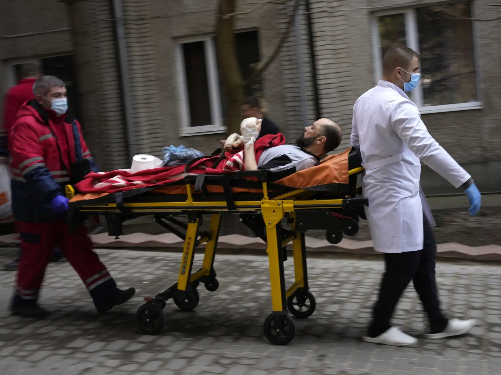 WA 49 Novojavorivsk - Záchranári privážajú zraneného muža do nemocnice v meste Novojavorivsk na západe Ukrajiny počas 18. dňa ruskej invázie na Ukrajinu v nedeľu 13. marca 2022.  FOTO TASR/AP 

An injured man is wheeled on a stretcher at a local hospital in Novoiavorisk, western Ukraine, Sunday, March 13, 2022. Local officials in western Ukraine say a Russian airstrike has hit a military training base that has hosted NATO drills. (AP Photo/Bernat Armangue)