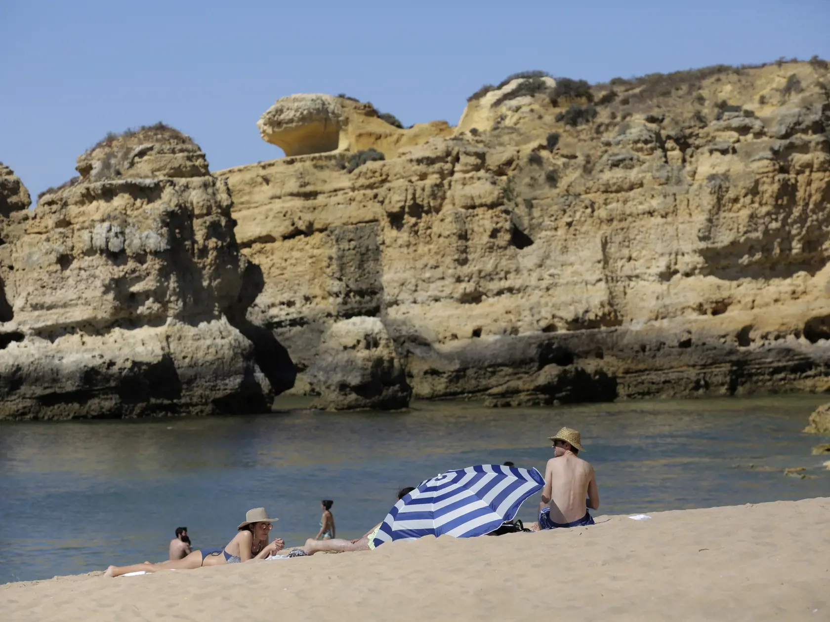 Dovolenkári sa opaľujú na pláži v Albufeire, v turistickom regióne Algarve na juhu Portugalska v utorok 18. mája 2021. Britskí dovolenkári začali v pondelok prichádzať do Portugalska po tom, čo Británia a portugalská vláda zmiernili cestovné obmedzenia spojené s pandémiou ochorenia COVID-19.  Očakáva sa, že v priebehu pondelka do krajiny pricestuje v rámci 17 letov viac ako 5000 Britov.