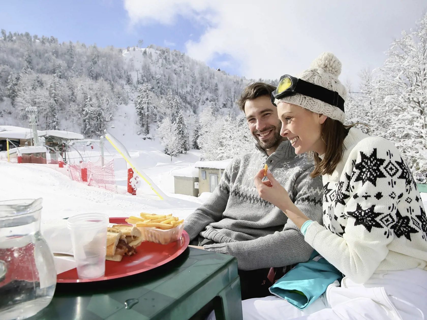 Couple of skiers having a snack on skiing day