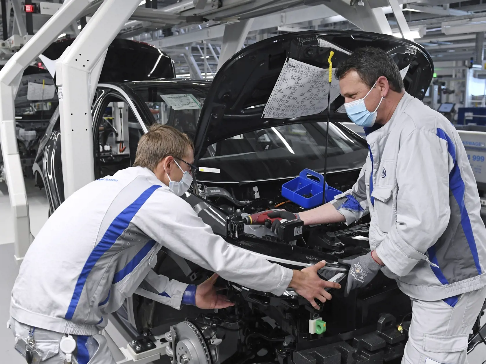 WA 32 Zwickau - Zamestnanci Max Brühmann (vľavo) a Heiko Gruner s ochrannými rúškami pracujú na výrobnej linke nemeckej automobilky Volkswagen, ktorá opätovne obnovila výrobu v závode v nemeckom meste Zwickau vo štvrtok 23. apríla 2020. Volkswagen začína postupným obnovením výroby. Opätovný nábeh výroby budú sprevádzať prísne epidemiologické opatrenia. Spoločnosť kompletne zmenila závod v Zwickau na výrobu áut na elektrický pohon. FOTO TASR/AP 


Max Bruehmann (l) and Heiko Gruner employees of G