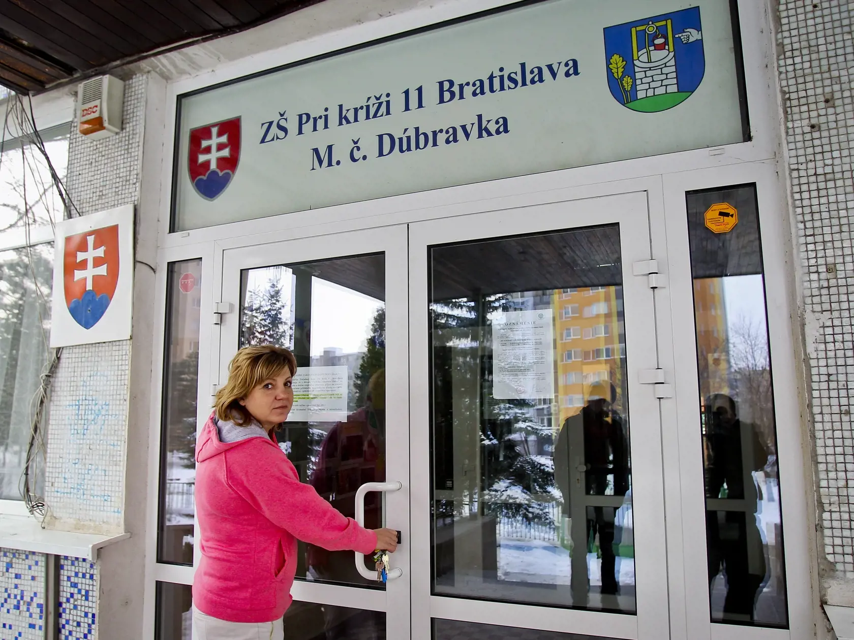 Na snimke riaditelka Mgr. Iveta Miksikova stoji pri zamknutych dverach budovy Zakladnej skoly Pri Krizi v bratislavskej mestskej casti Dubravka, kde na zaklade odporucania Regionalneho uradu verejneho zdravotnictva-epidemilogie, pozastavili vyucovavi proces z dovodu vysoke poctu ochoreni ziakov na chripku.