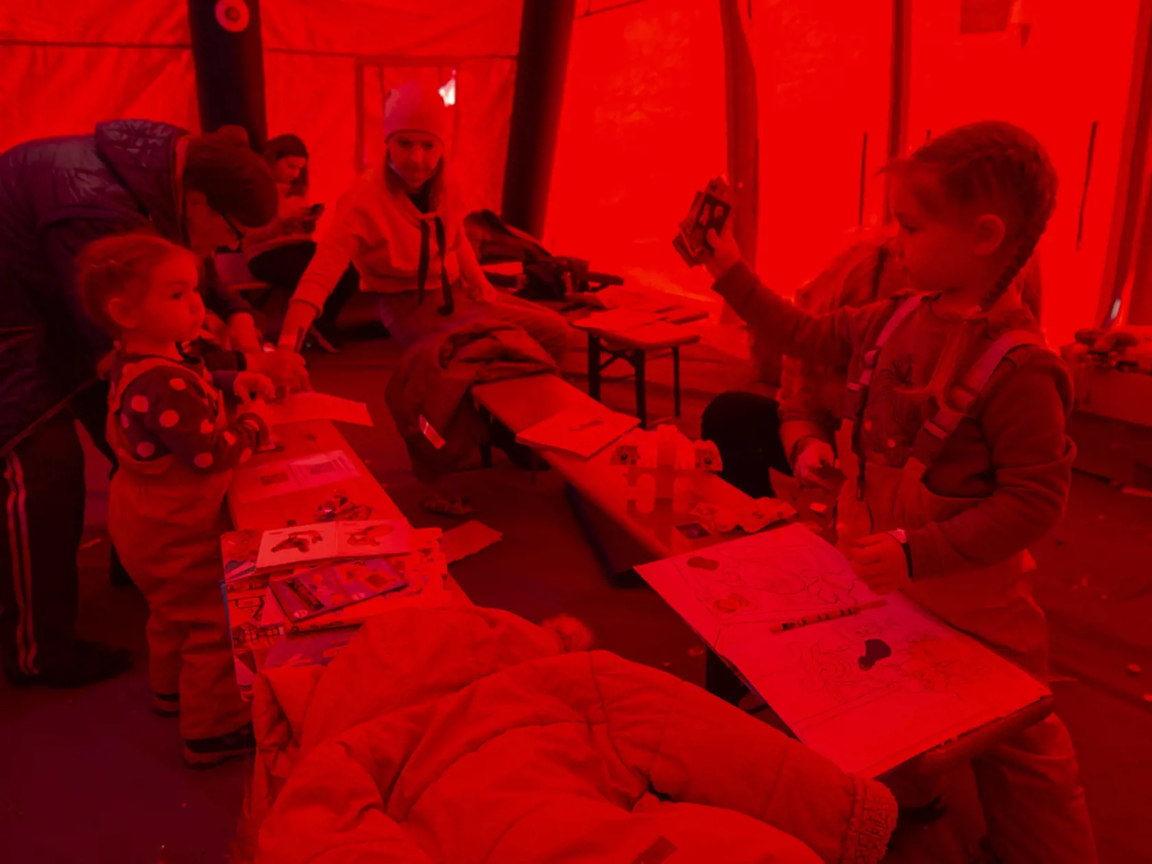 Na snímke hrajúce sa deti vo vyhrievanom stane. Utečenci z Ukrajiny si prišli na Oddelenie cudzineckej polície vybaviť doklady v Bratislave 11. marca 2022. FOTO TASR - Martin Baumann